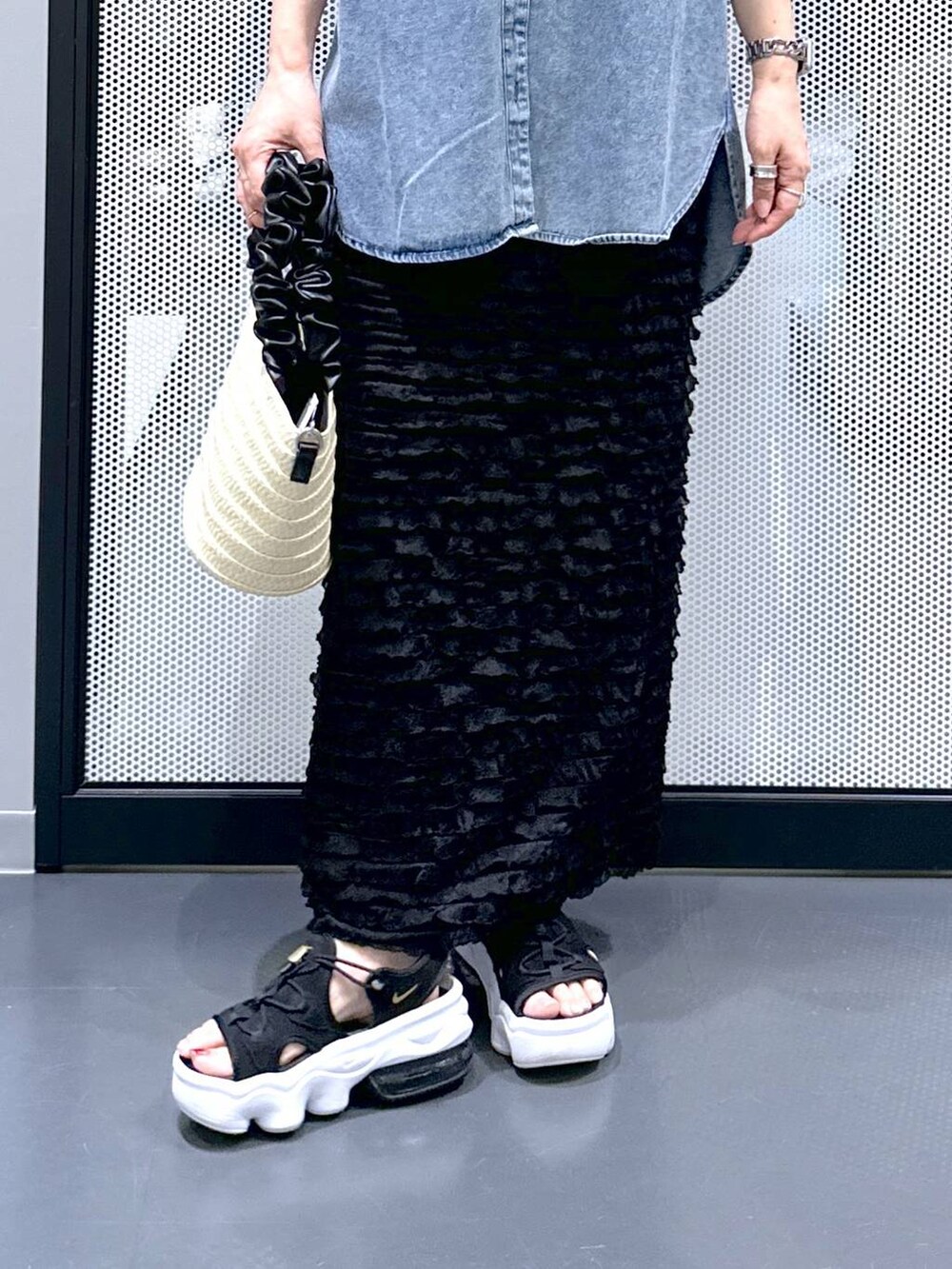 ブラック系のショルダーバッグ、ホワイト系のベスト、ブルー系のシャツ/ブラウスを着用したレディースの夏コーディネートの5枚目の写真