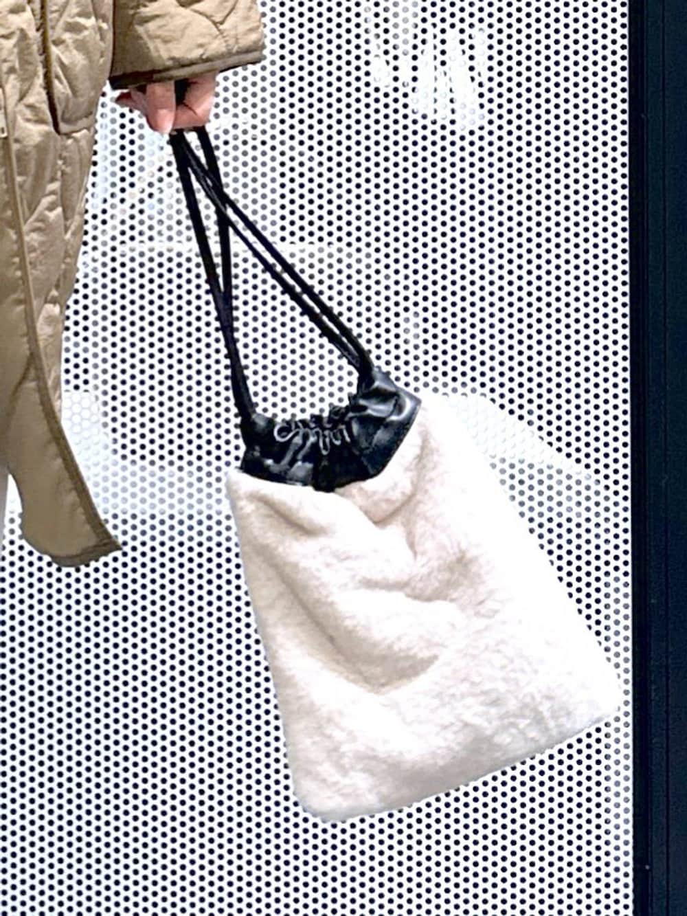 ブラウン系のスニーカー、ベージュ系のショルダーバッグ、グリーン系のナイロンジャケットを着用したレディースの冬コーディネートの10枚目の写真