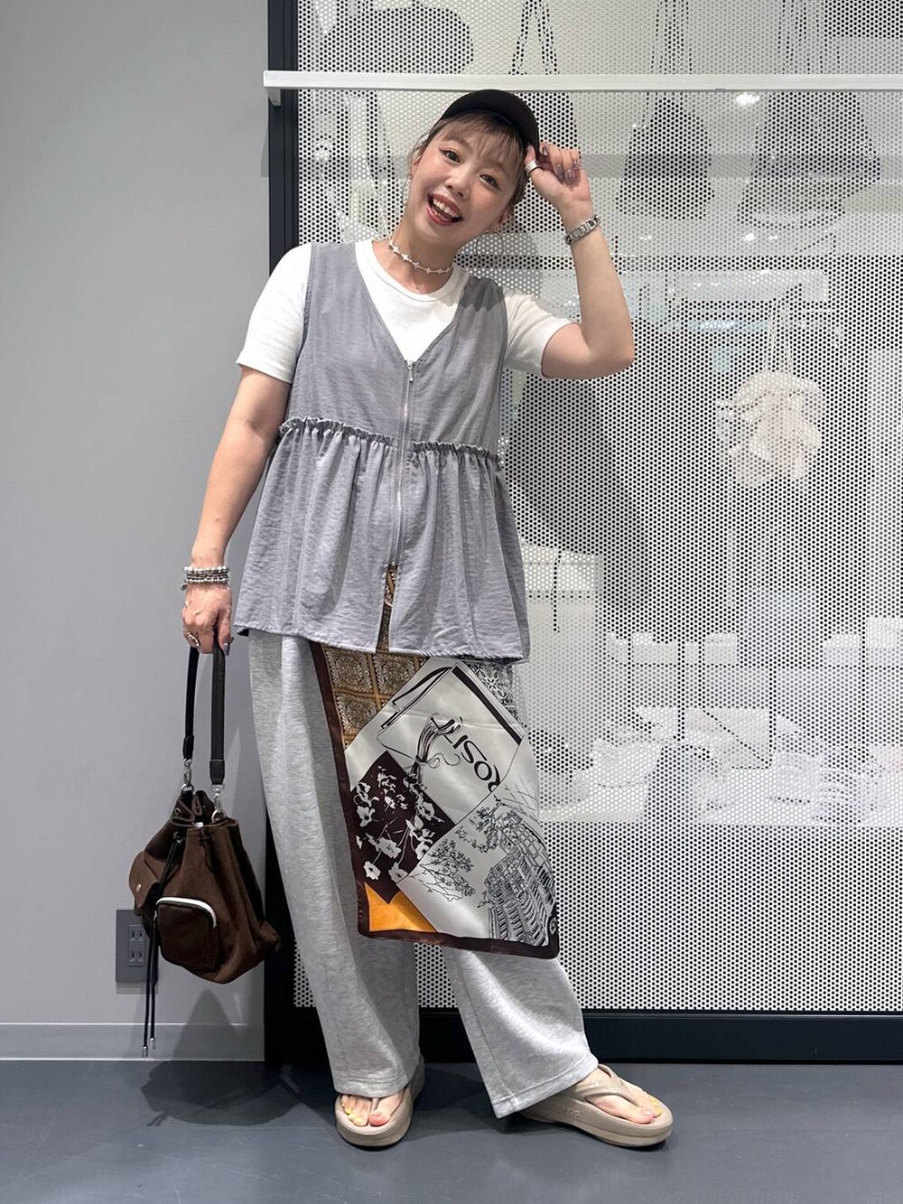 ホワイト系のTシャツ/カットソー、ブラウン系のショルダーバッグ、ベージュ系のサンダルを着用したレディースの夏コーディネートの2枚目の写真