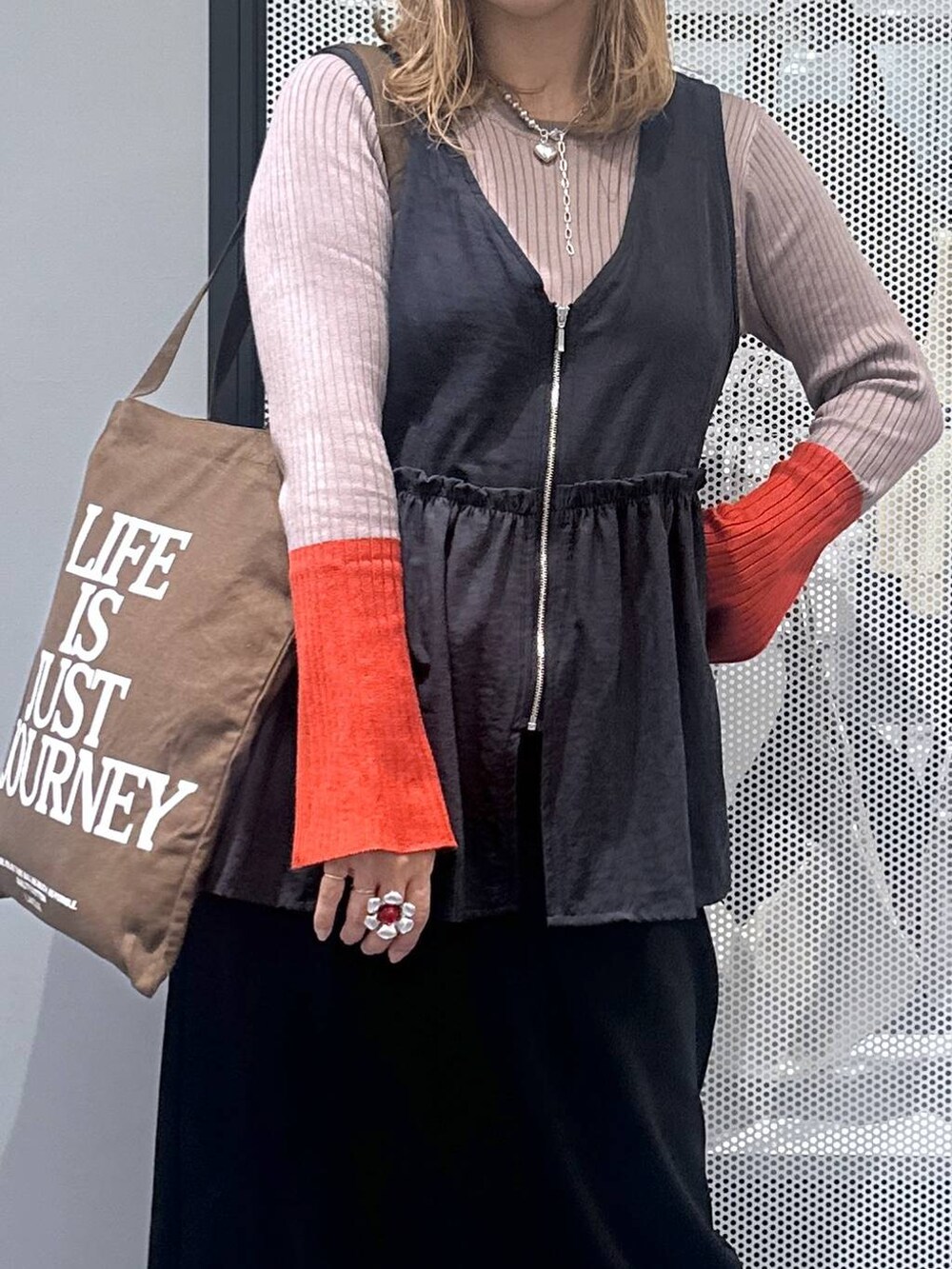 ブラック系のスカート、ブラウン系のトートバッグ、ブラウン系のニット/セーターを着用したレディースの秋コーディネートの4枚目の写真