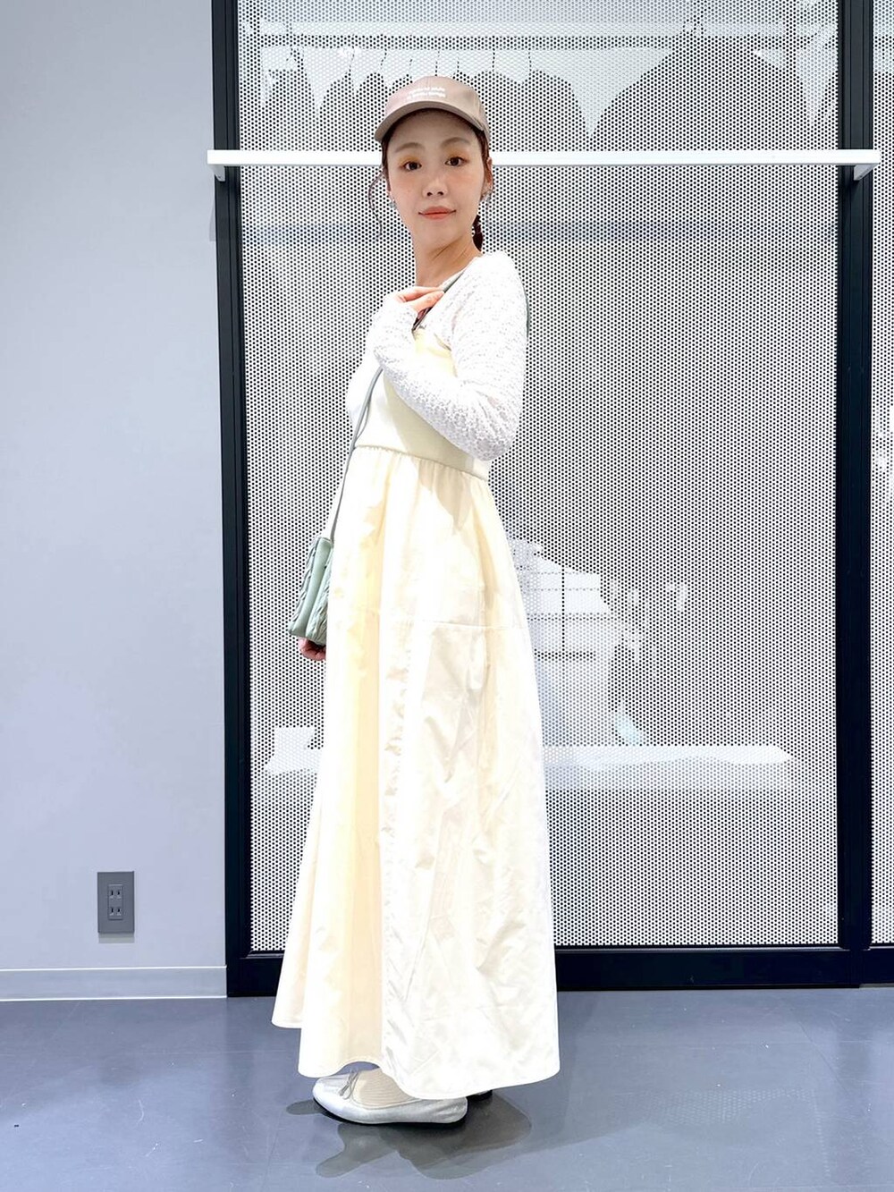 グリーン系のショルダーバッグ、シルバー系のバレエシューズ、ホワイト系のTシャツ/カットソーを着用したレディースの春コーディネートの5枚目の写真