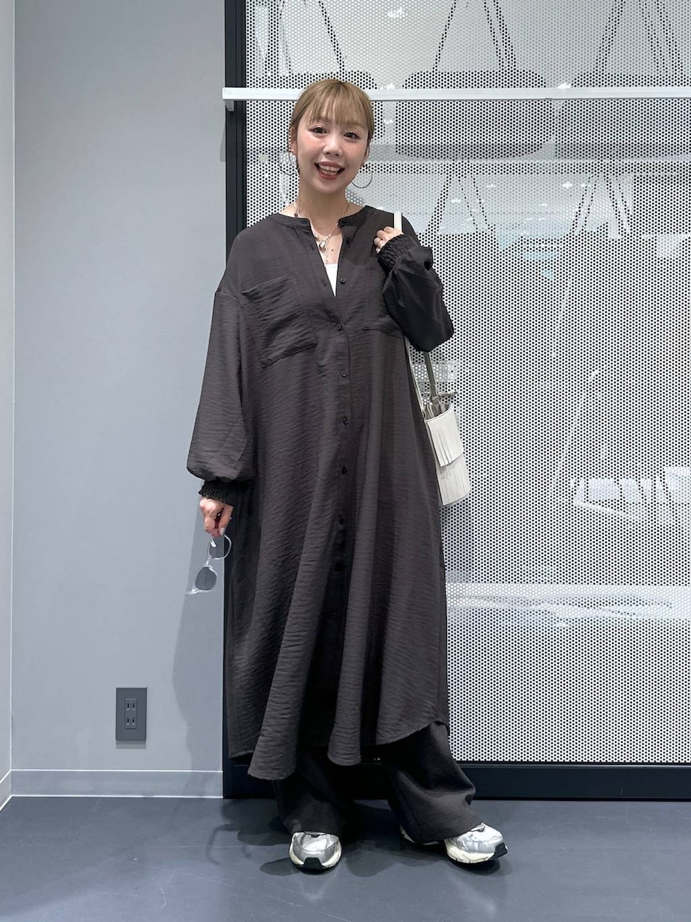 グレー系のその他パンツ、ホワイト系のタンクトップ、ホワイト系のショルダーバッグを着用したレディースの秋コーディネートの2枚目の写真