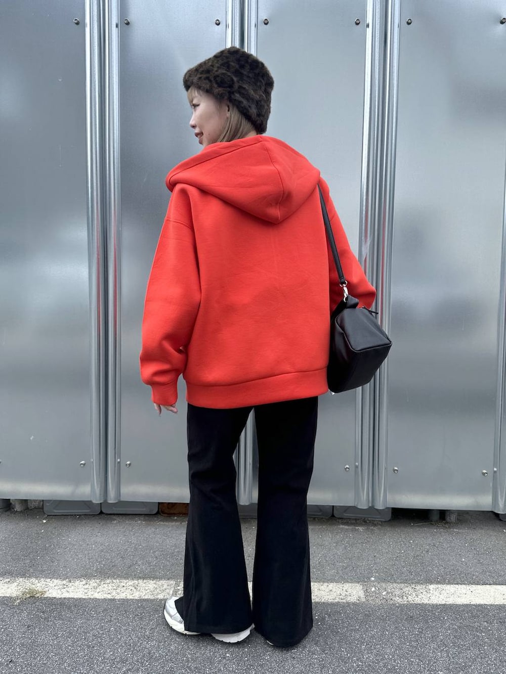 ブラック系のショルダーバッグ、レッド系のパーカー、ブラック系のその他パンツを着用したレディースの秋コーディネートの3枚目の写真