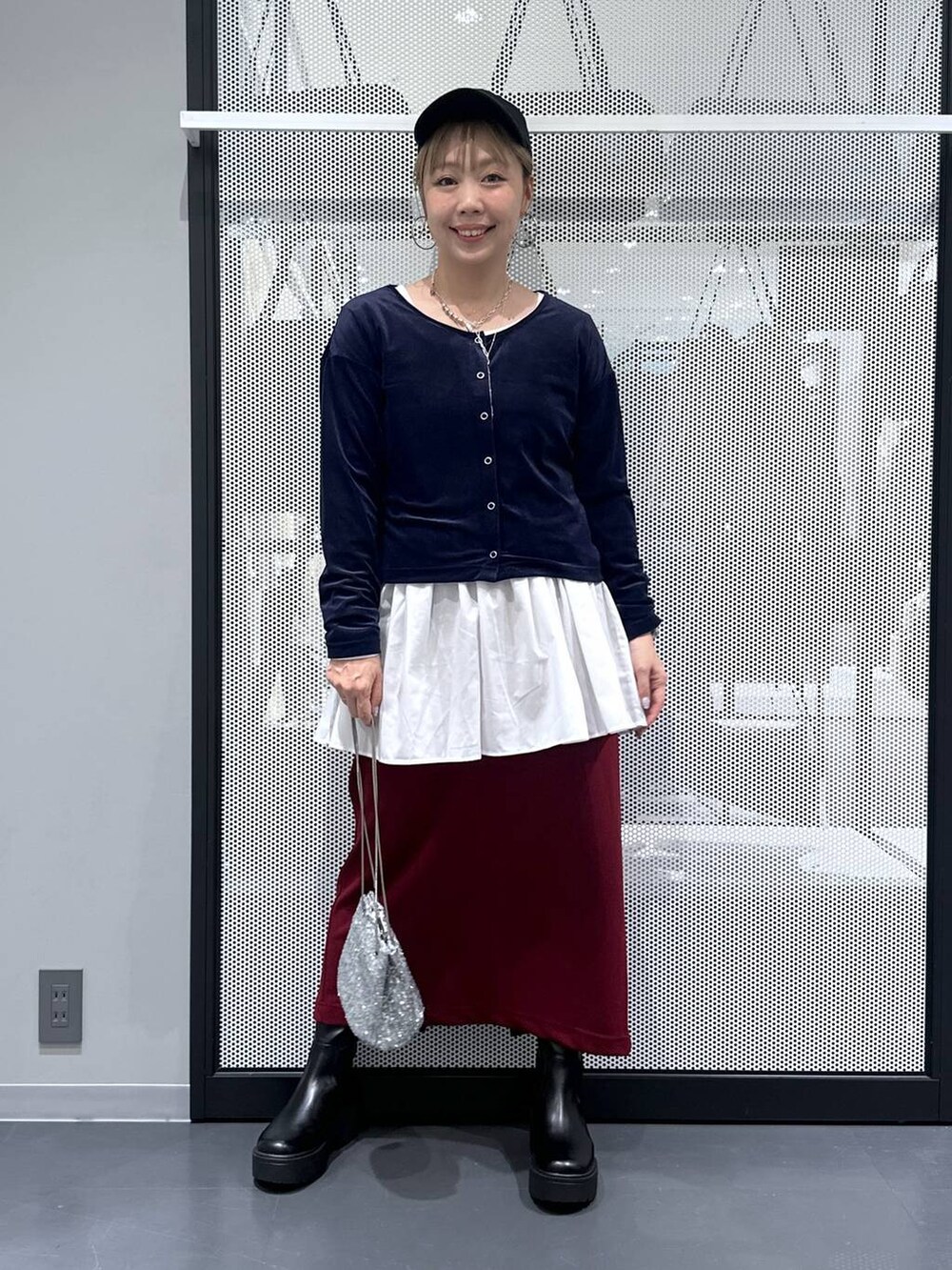 レッド系のスカート、シルバー系のショルダーバッグ、ブルー系のTシャツ/カットソーを着用したレディースの秋コーディネートの2枚目の写真