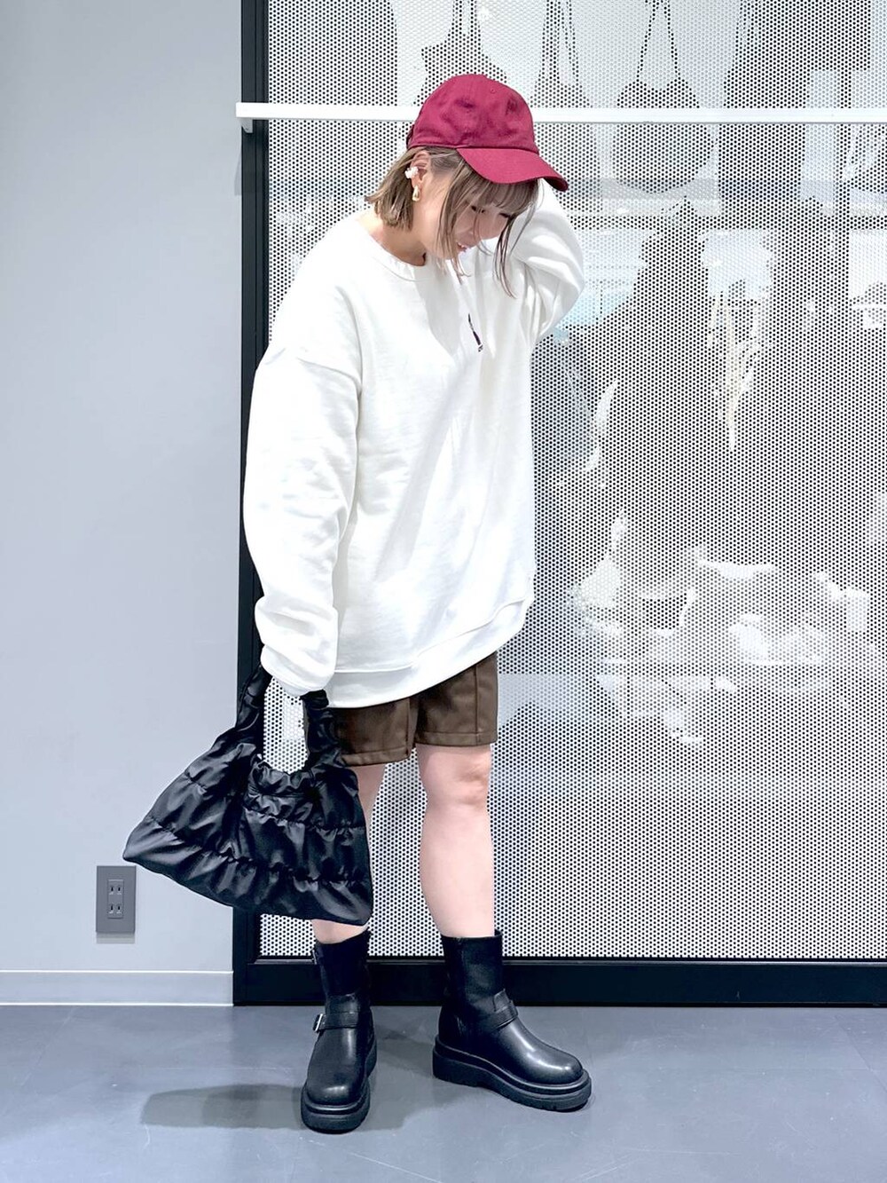 ベージュ系のブルゾン、ブラック系のブーツ、ホワイト系のスウェットを着用したレディースの冬コーディネートの6枚目の写真