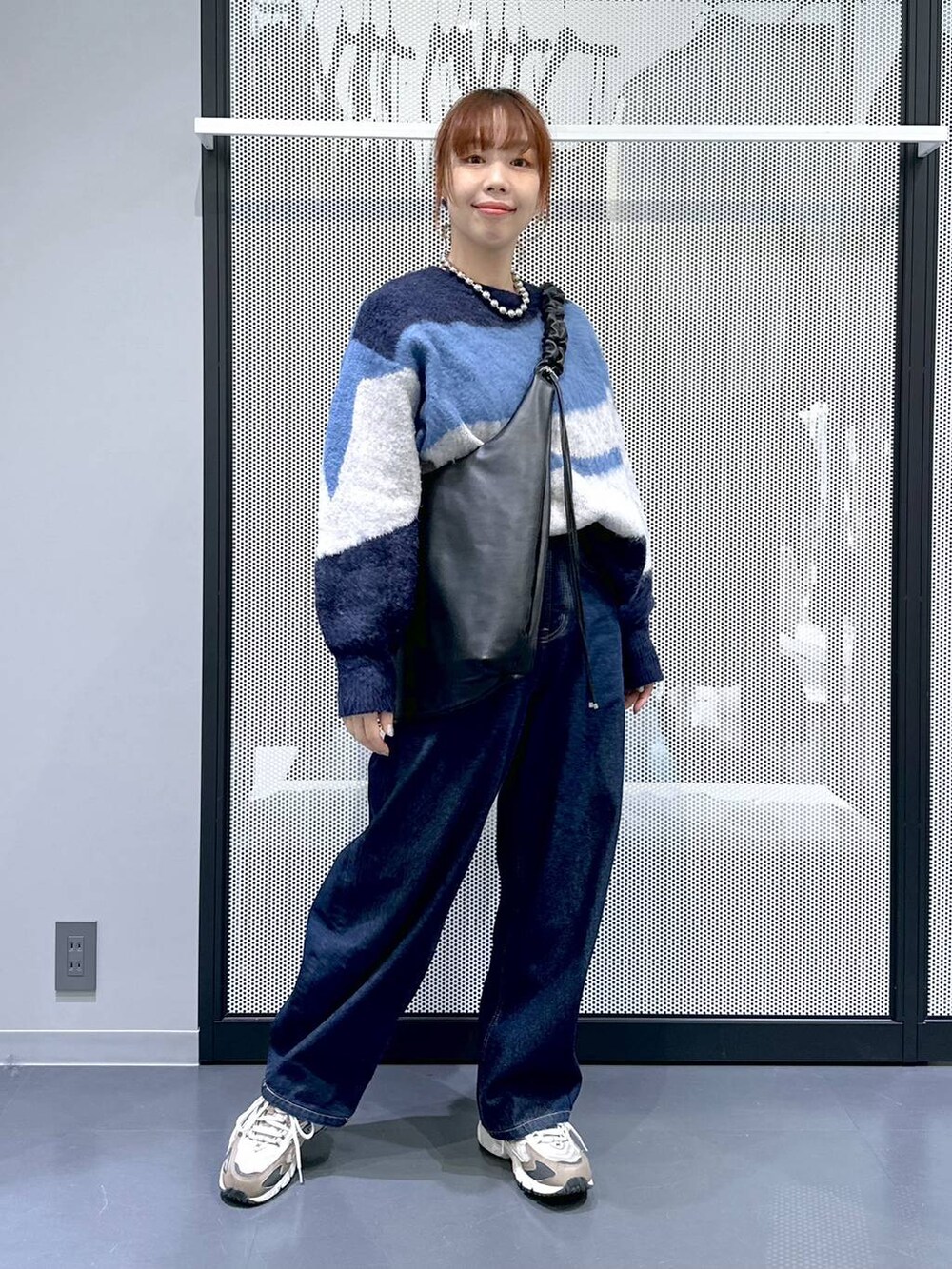 ブラウン系のスニーカー、ホワイト系のTシャツ/カットソー、ブルー系のデニムパンツを着用したレディースの冬コーディネートの2枚目の写真