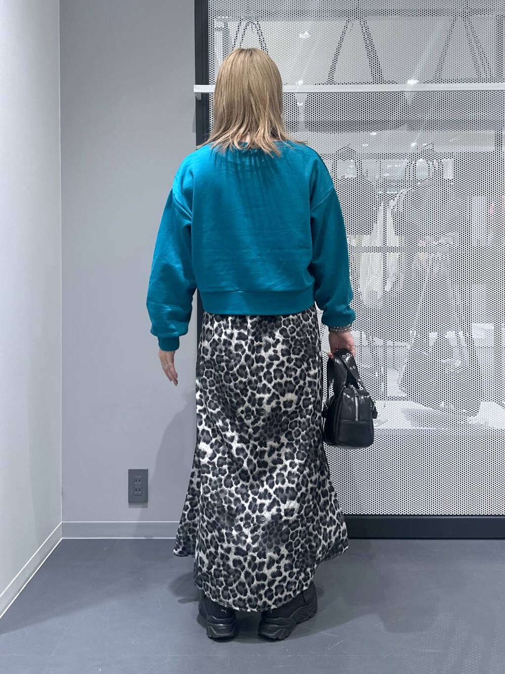 ブラック系のショルダーバッグ、グレー系のスカート、ブルー系のスウェットを着用したレディースの秋コーディネートの3枚目の写真