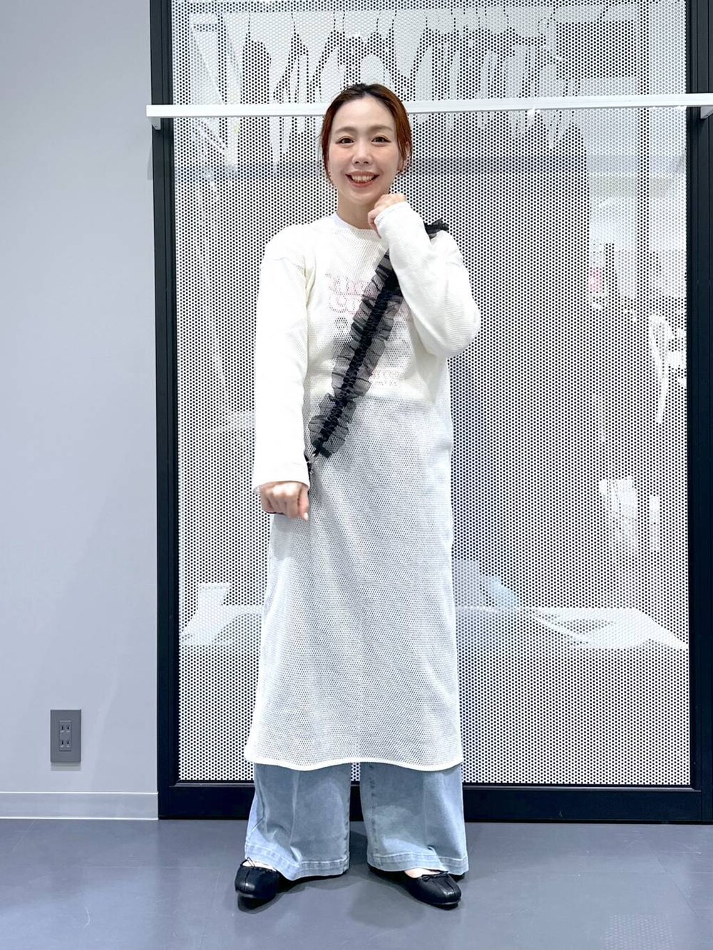 ブルー系のデニムパンツ、ホワイト系のワンピース、ブラック系のバレエシューズを着用したレディースの春コーディネートの4枚目の写真