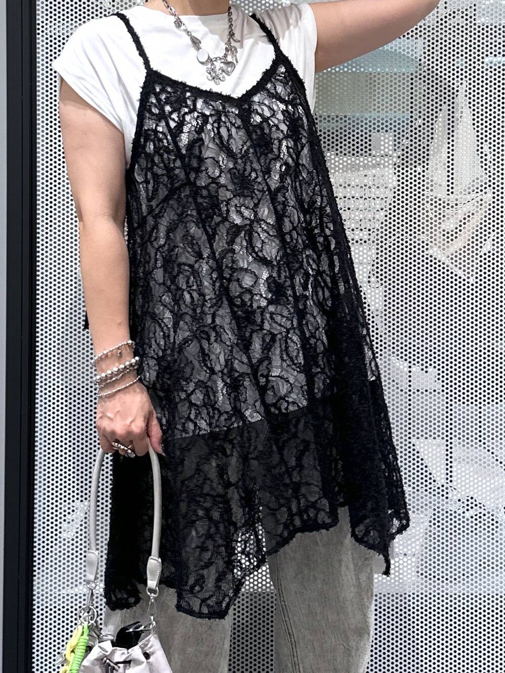 ホワイト系のショルダーバッグ、ホワイト系のTシャツ/カットソー、ブラック系のチュニックを着用したレディースの夏コーディネートの4枚目の写真