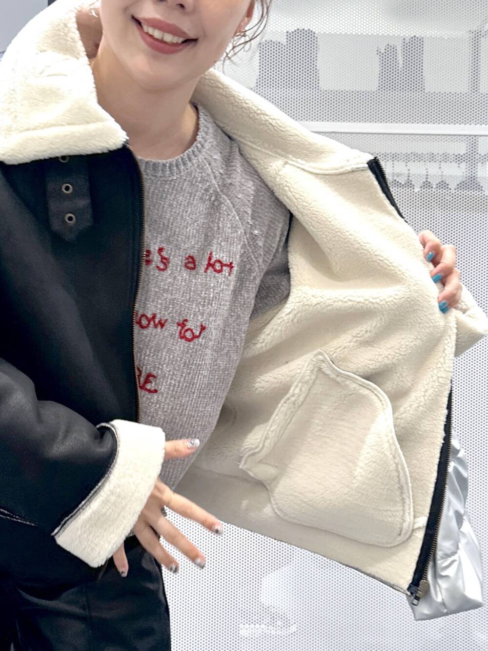 ブラック系のブルゾン、ブラック系のブーツ、シルバー系のショルダーバッグを着用したレディースの秋コーディネートの7枚目の写真