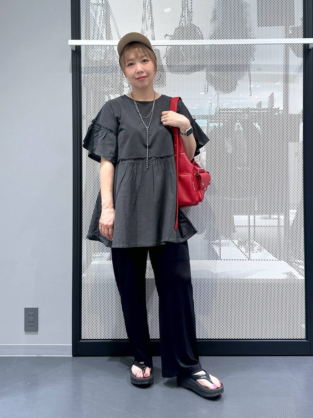 レッド系のショルダーバッグ、ブラック系のサンダル、ブラック系のその他パンツを着用したレディースの夏コーディネートの6枚目の写真