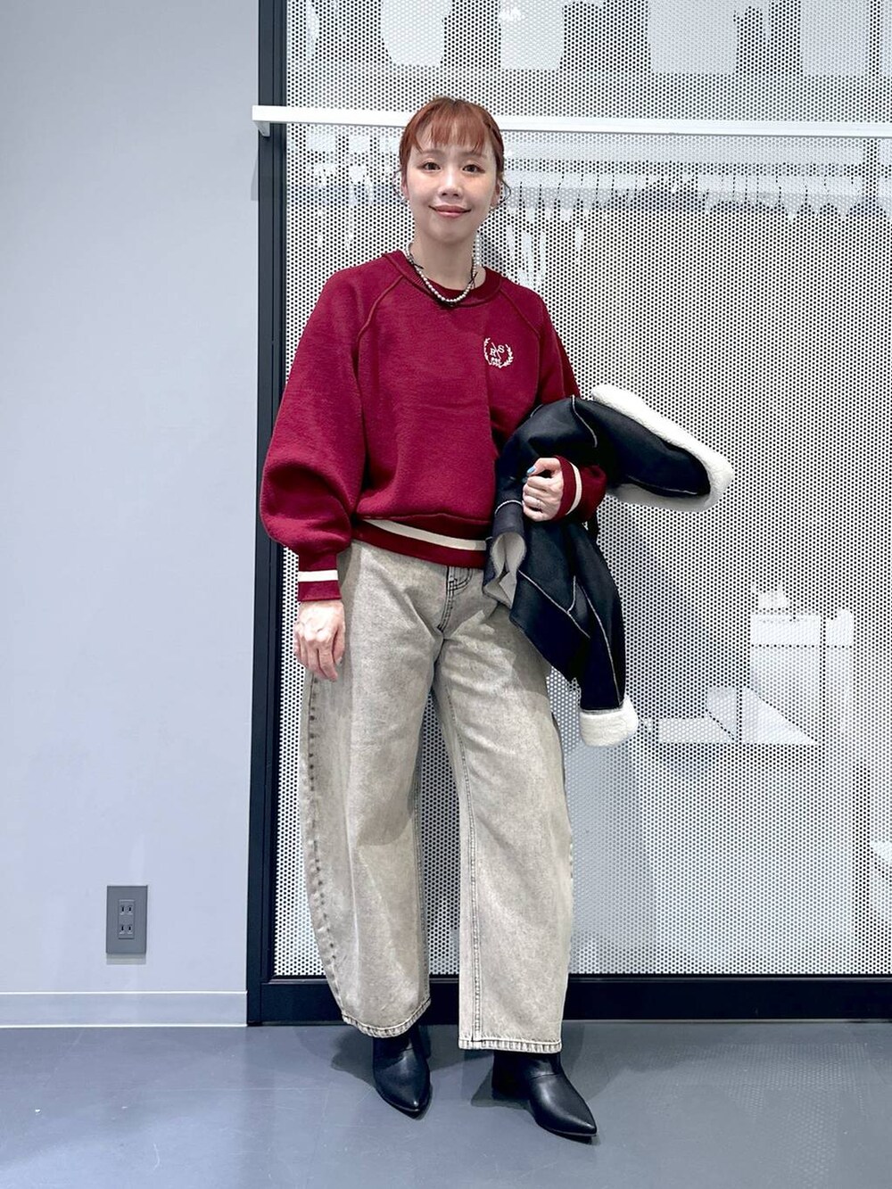 ブラック系のショルダーバッグ、ブラック系のブルゾン、ベージュ系のデニムパンツを着用したレディースの秋コーディネートの2枚目の写真