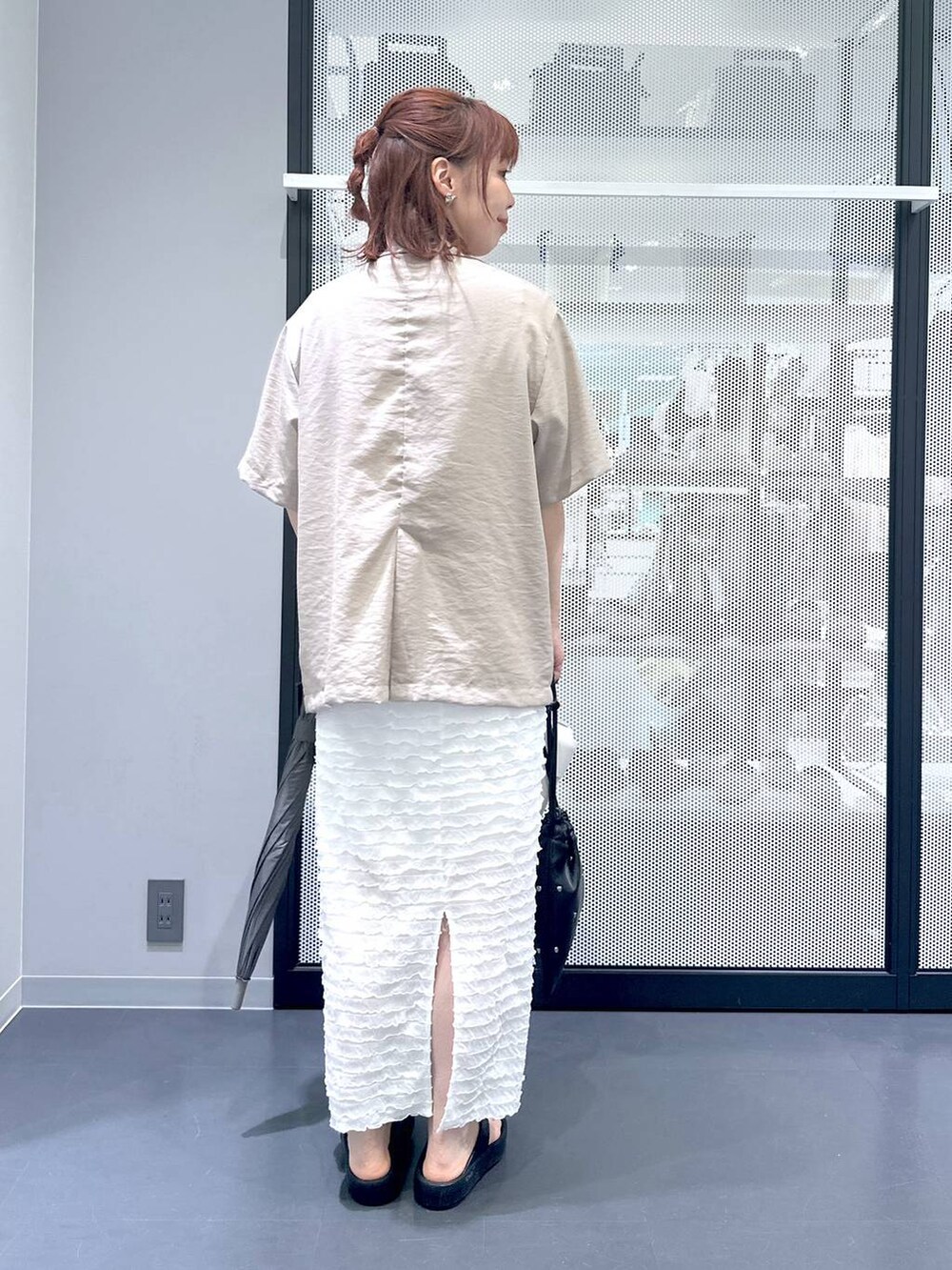 ブラック系のショルダーバッグ、ホワイト系のベスト、ホワイト系のTシャツ/カットソーを着用したレディースの夏コーディネートの4枚目の写真