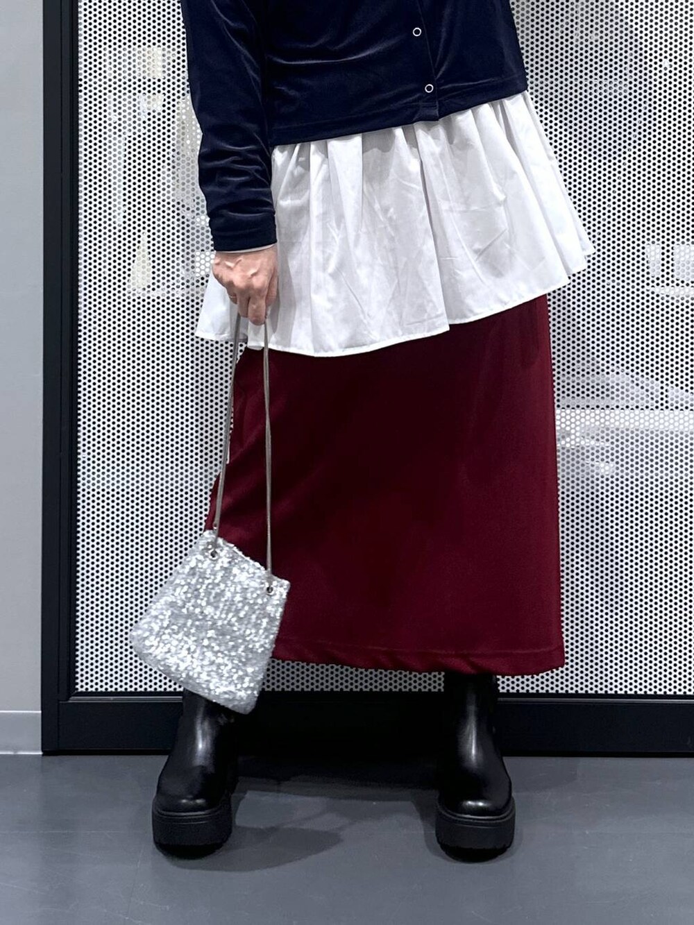 レッド系のスカート、シルバー系のショルダーバッグ、ブルー系のTシャツ/カットソーを着用したレディースの秋コーディネートの5枚目の写真