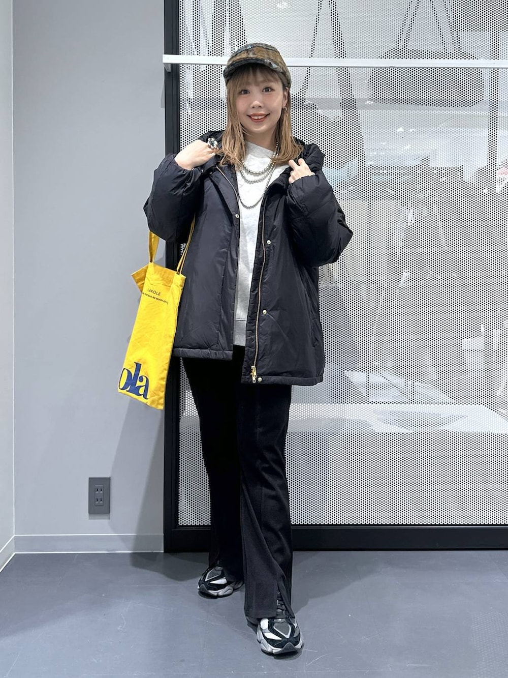 イエロー系のトートバッグ、ブラック系のダウンジャケット/コート、ブラック系のその他パンツを着用したレディースの冬コーディネートの8枚目の写真