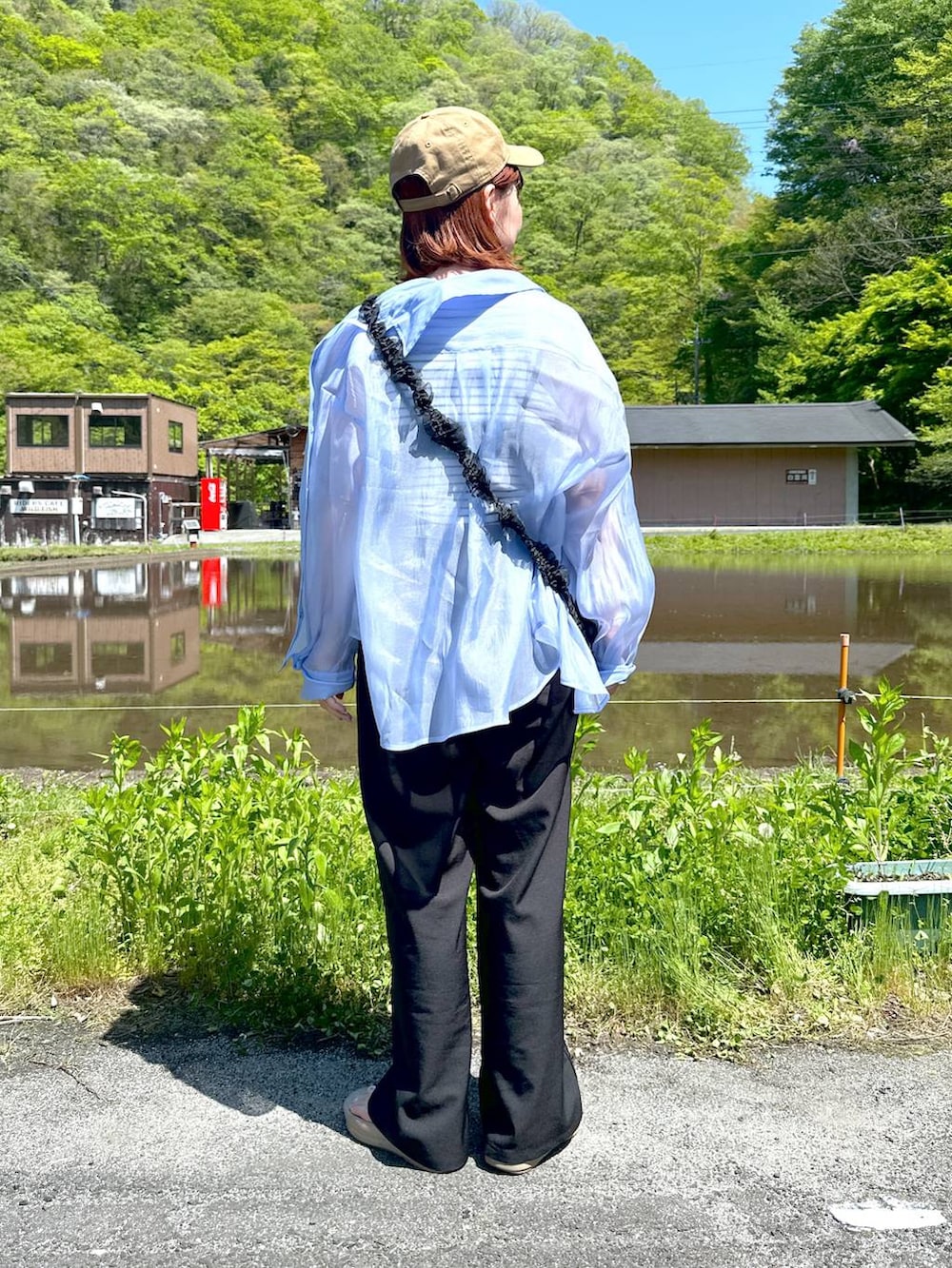 ブルー系のシャツ/ブラウス、ベージュ系のサンダル、ブラック系のサロペット/オーバーオールを着用したレディースの春コーディネートの3枚目の写真