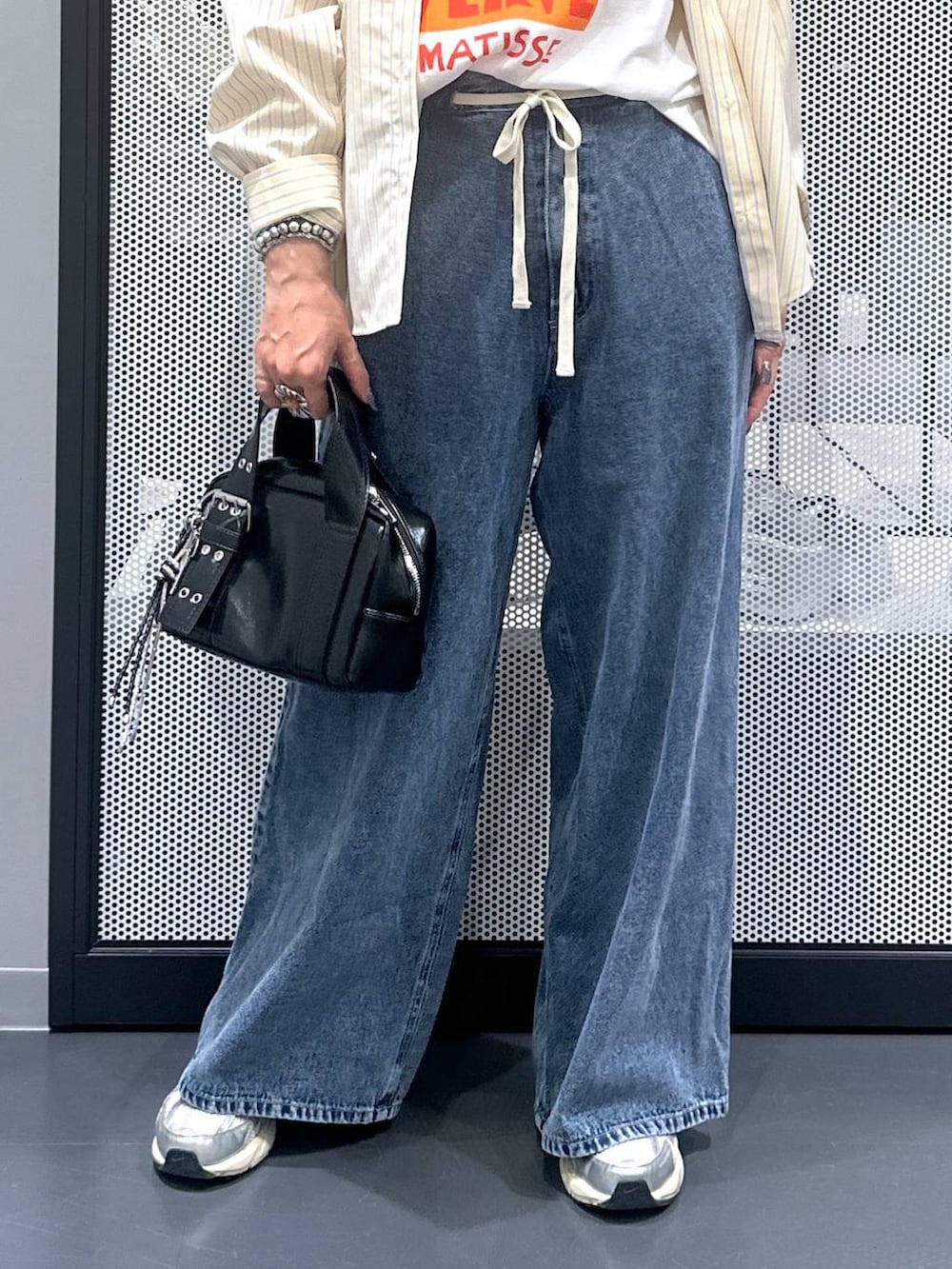 ブラック系のショルダーバッグ、ブルー系のデニムパンツ、ホワイト系のTシャツ/カットソーを着用したレディースの夏コーディネートの5枚目の写真