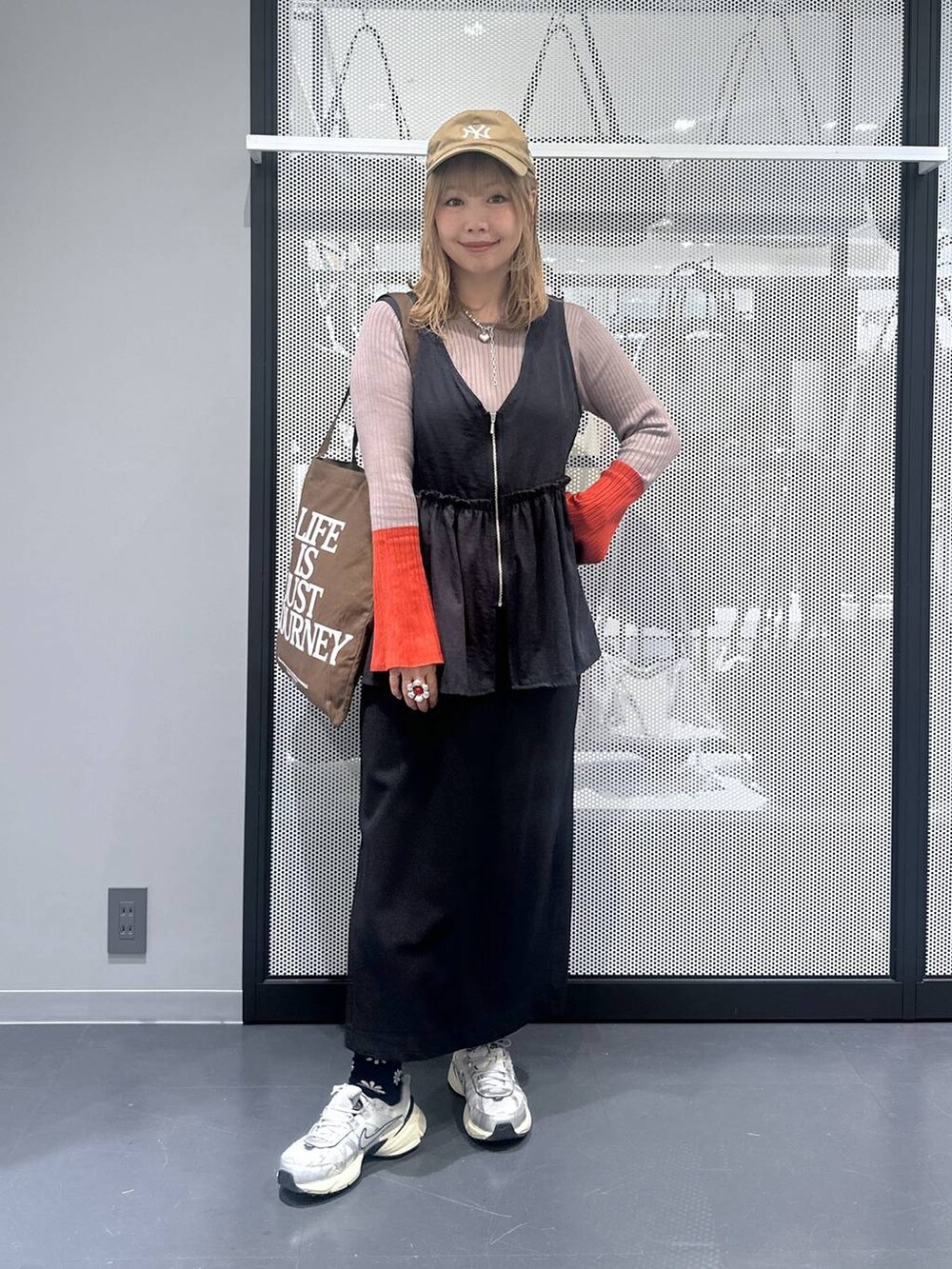 ブラック系のスカート、ブラウン系のトートバッグ、ブラウン系のニット/セーターを着用したレディースの秋コーディネートの6枚目の写真