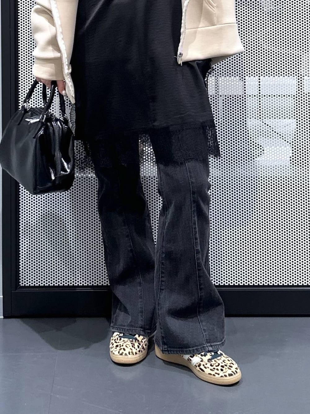 ブラック系のショルダーバッグ、ホワイト系のTシャツ/カットソー、ブラック系のデニムパンツを着用したレディースの冬コーディネートの4枚目の写真