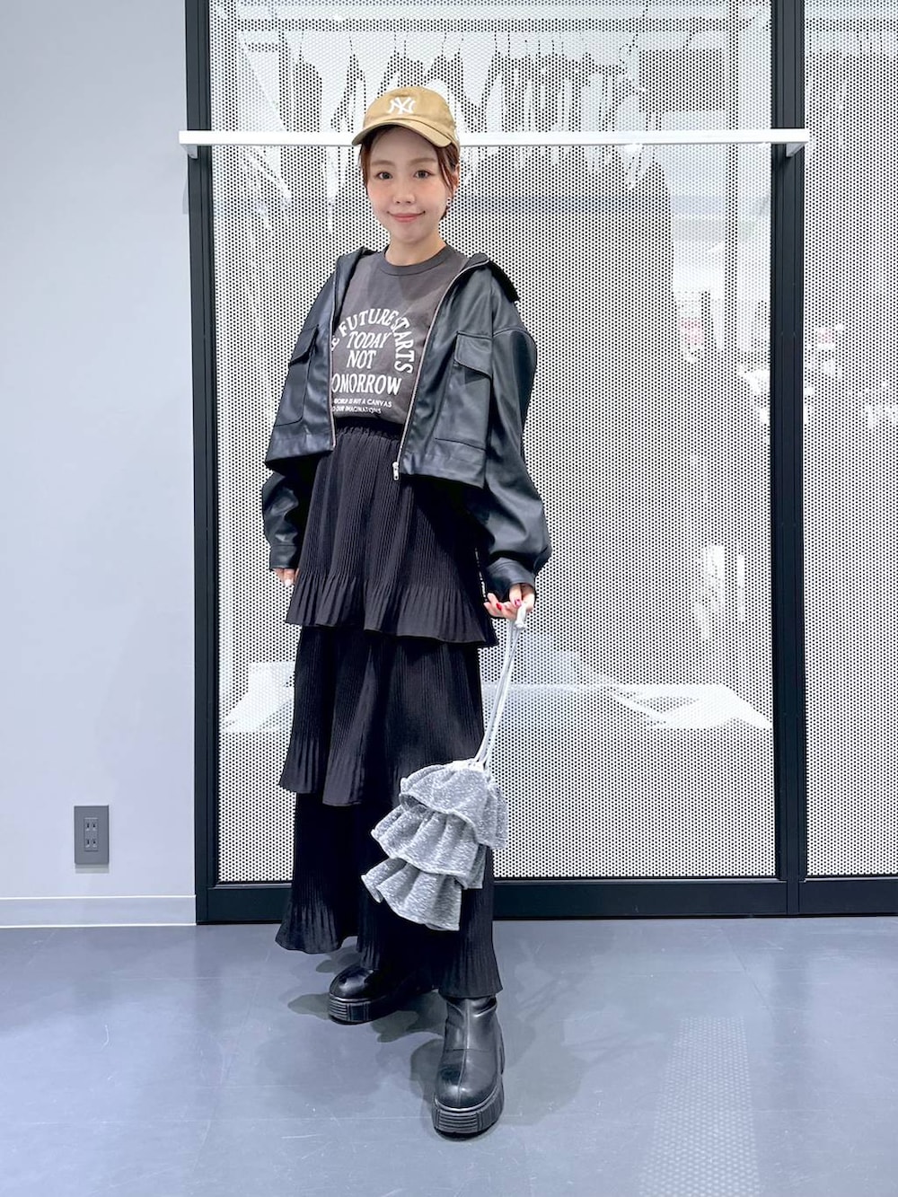 グレー系のデニムジャケット、シルバー系のショルダーバッグ、ブラック系のスカートを着用したレディースの春コーディネートの6枚目の写真