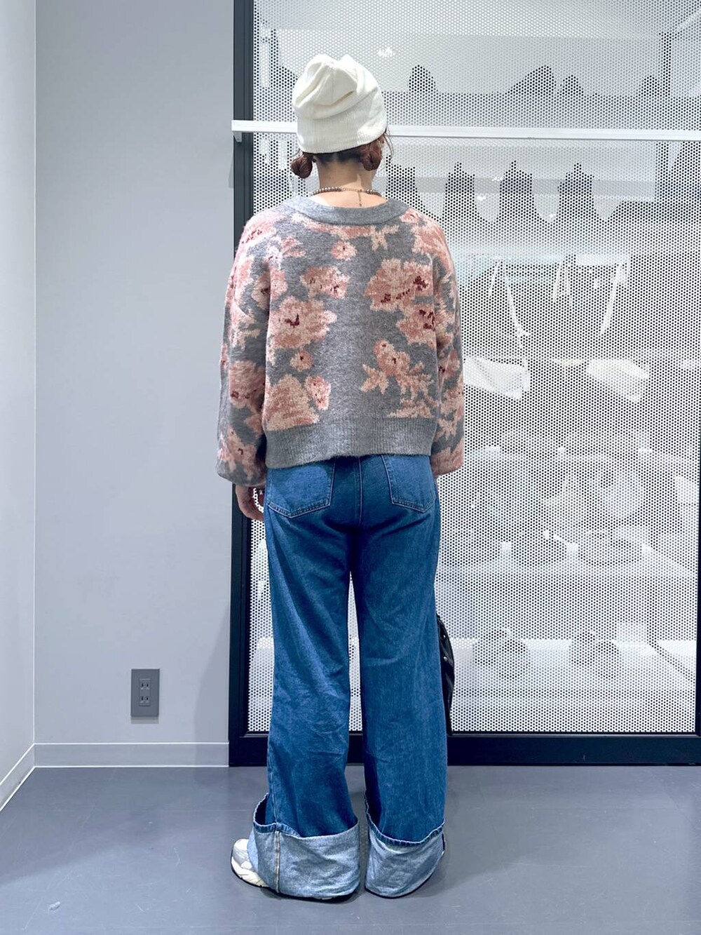 ブラック系のショルダーバッグ、ブルー系のデニムパンツ、グレー系のカーディガン/ボレロを着用したレディースの秋コーディネートの3枚目の写真