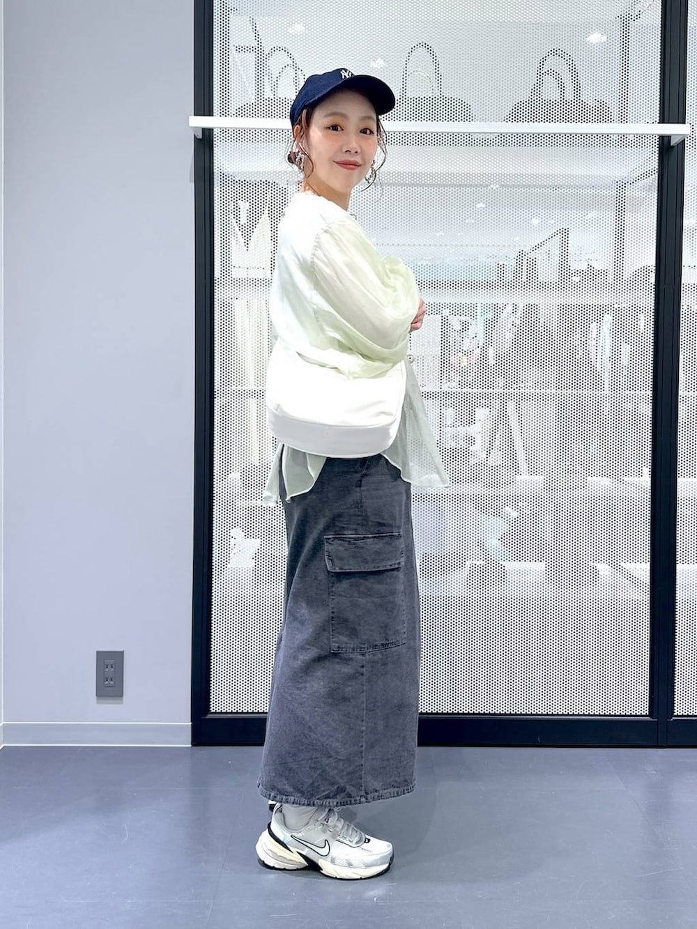 グレー系のデニムスカート、ホワイト系のTシャツ/カットソー、ホワイト系のショルダーバッグを着用したレディースの春コーディネートの3枚目の写真