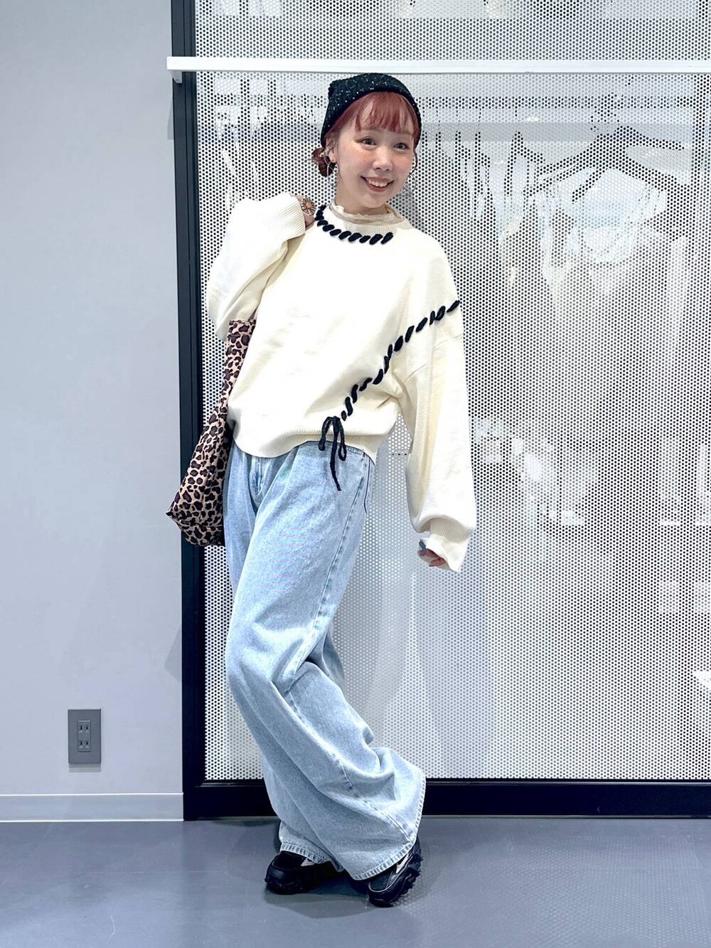 グレー系のスニーカー、ベージュ系のトートバッグ、ブルー系のデニムパンツを着用したレディースの秋コーディネートの7枚目の写真