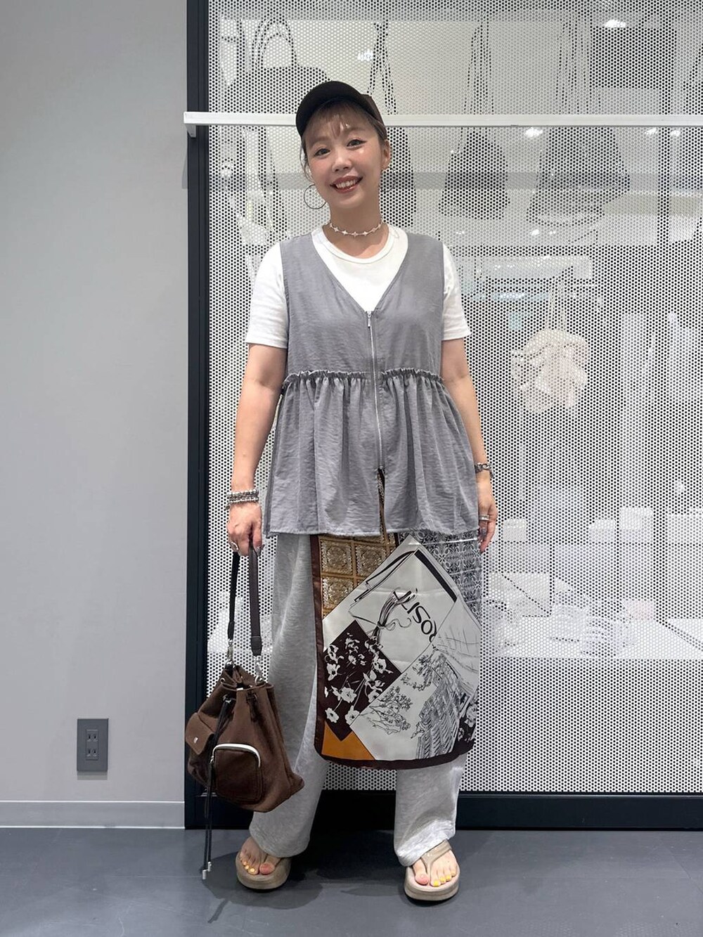 ホワイト系のTシャツ/カットソー、ブラウン系のショルダーバッグ、ベージュ系のサンダルを着用したレディースの夏コーディネートの6枚目の写真