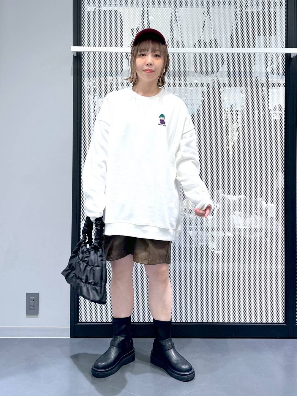 ベージュ系のブルゾン、ブラック系のブーツ、ホワイト系のスウェットを着用したレディースの冬コーディネートの5枚目の写真