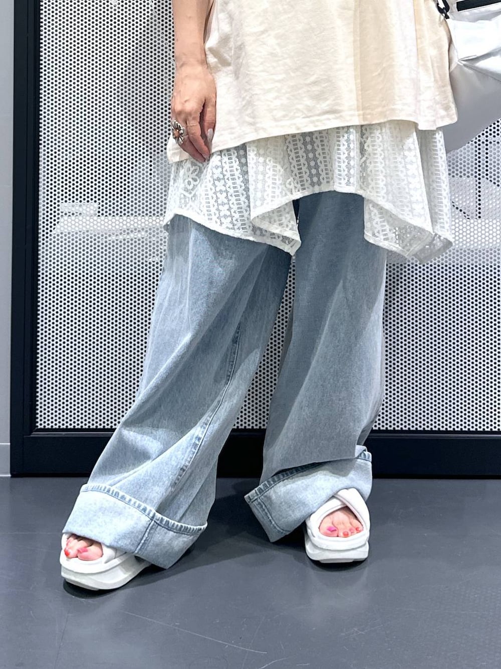 ホワイト系のショルダーバッグ、ブルー系のデニムパンツ、ベージュ系のワンピースを着用したレディースの夏コーディネートの5枚目の写真