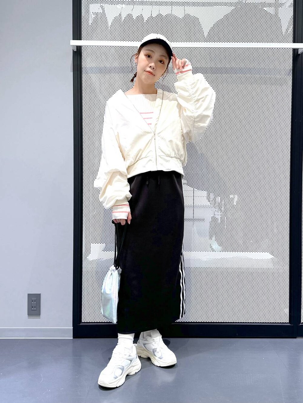 ブラック系のスカート、ベージュ系のMA-1、ピンク系のニット/セーターを着用したレディースの冬コーディネートの2枚目の写真