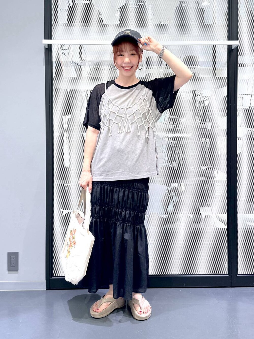 ホワイト系のベスト、ブラック系のスカート、その他のエコバッグ/サブバッグを着用したレディースの夏コーディネートの2枚目の写真