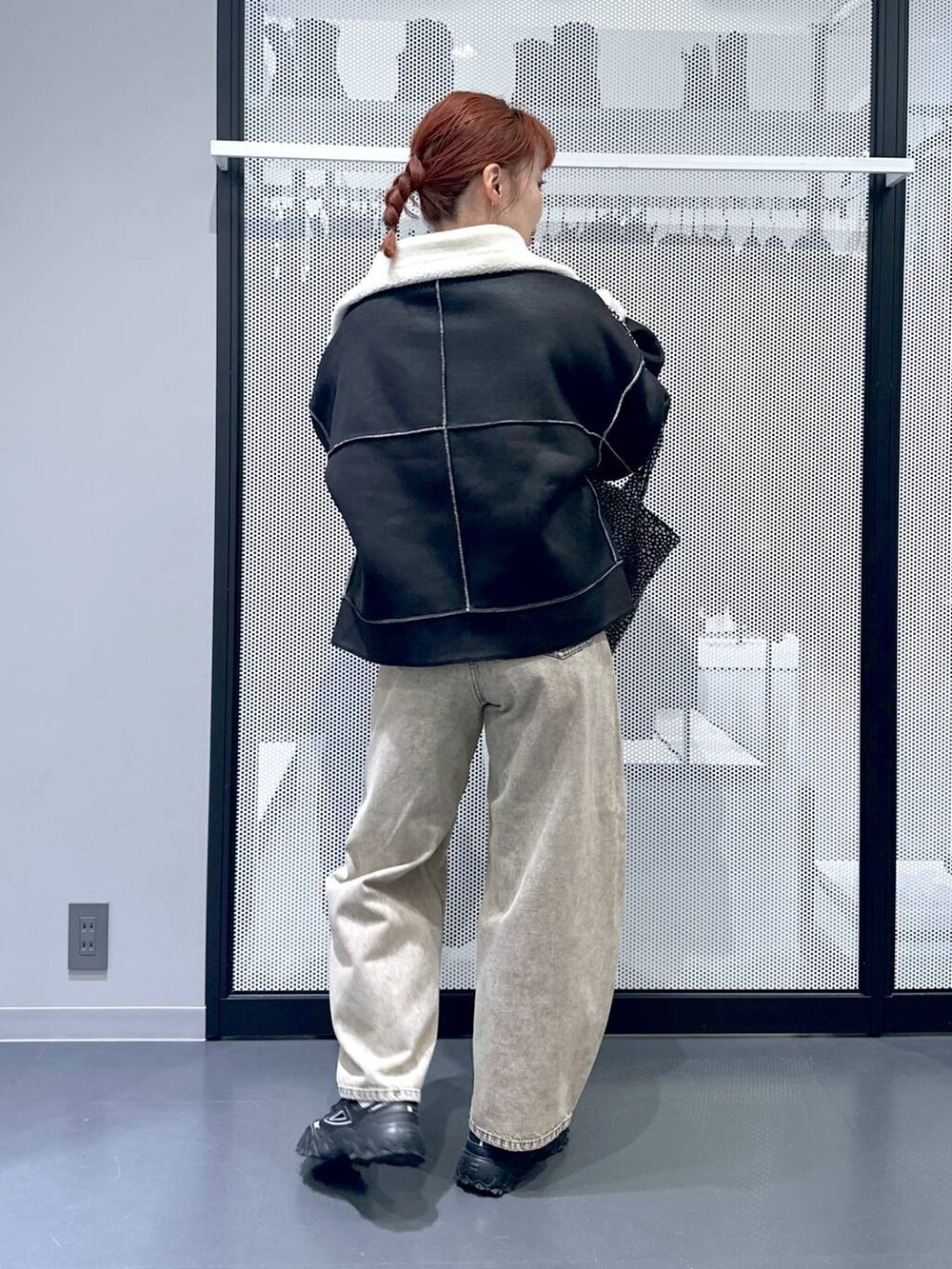 ブラック系のショルダーバッグ、ブラック系のブルゾン、ベージュ系のデニムパンツを着用したレディースの秋コーディネートの4枚目の写真