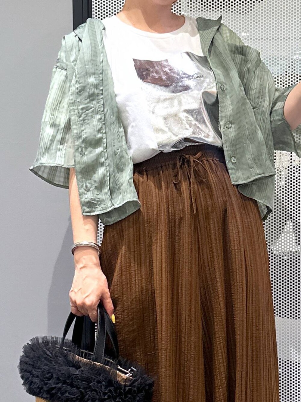 ベージュ系のショルダーバッグ、ホワイト系のTシャツ/カットソー、グリーン系のシャツ/ブラウスを着用したレディースの春コーディネートの4枚目の写真