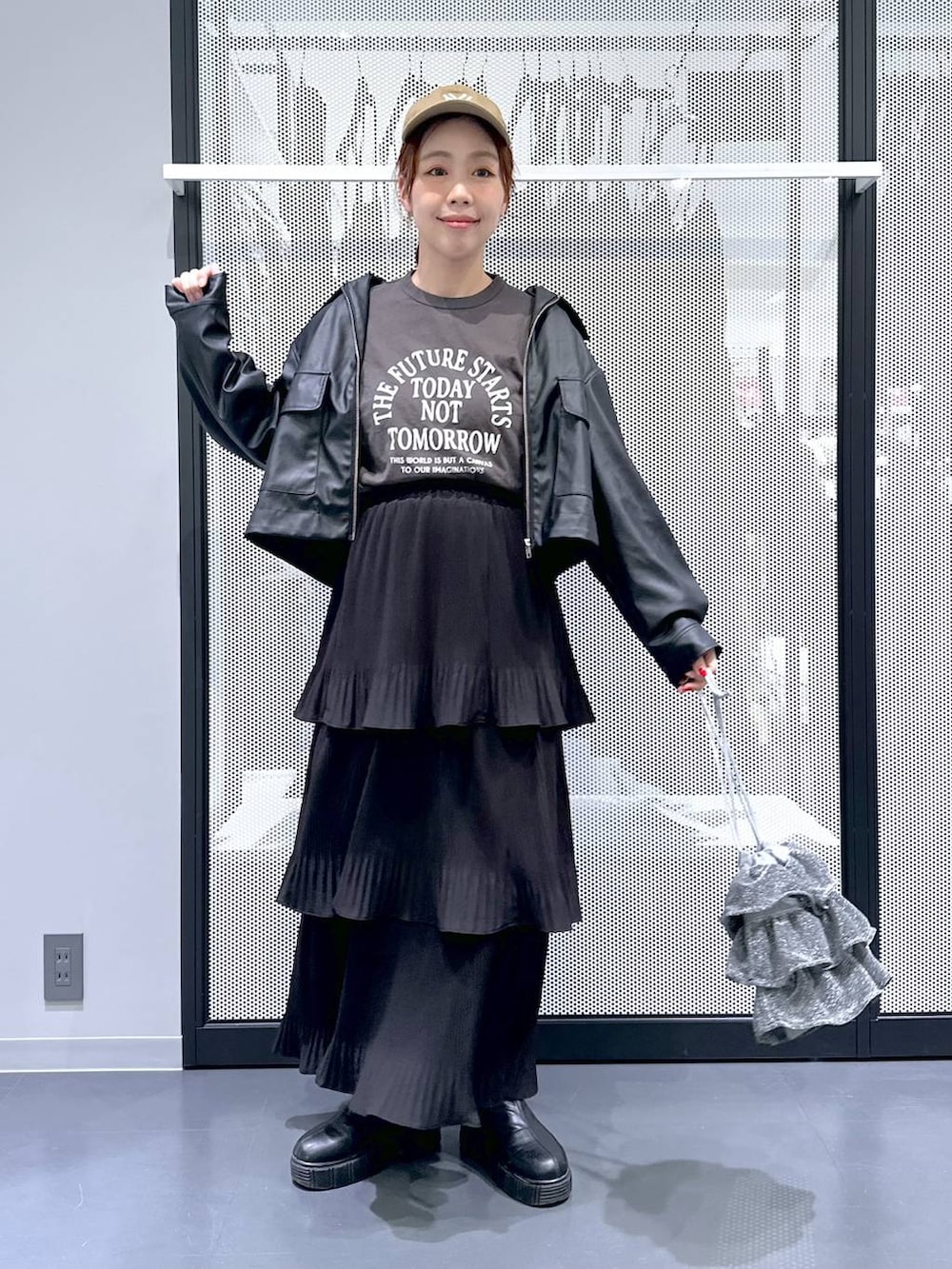 グレー系のデニムジャケット、シルバー系のショルダーバッグ、ブラック系のスカートを着用したレディースの春コーディネートの2枚目の写真