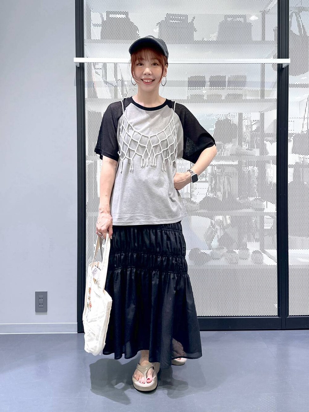 ホワイト系のベスト、ブラック系のスカート、その他のエコバッグ/サブバッグを着用したレディースの夏コーディネートの8枚目の写真