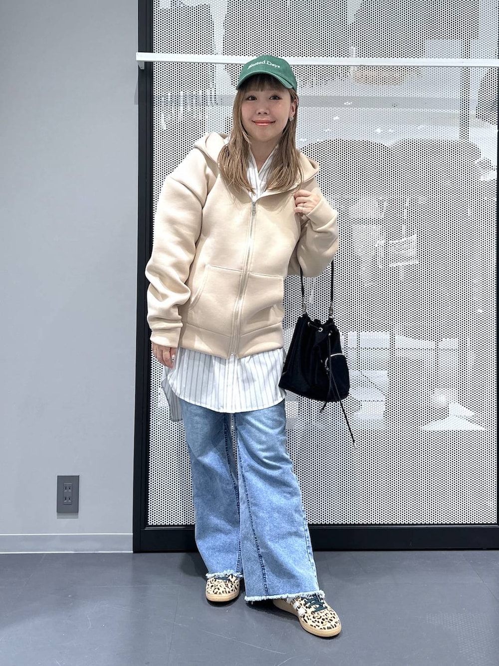 ホワイト系のシャツ/ブラウス、ブラック系のショルダーバッグ、ブルー系のデニムパンツを着用したレディースの春コーディネートの2枚目の写真