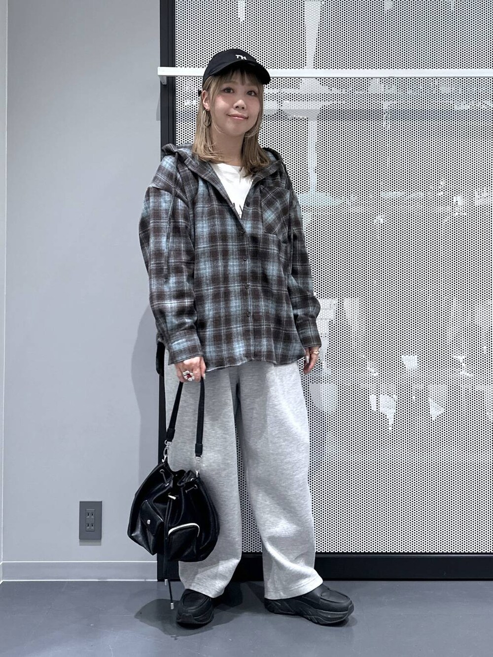 ブラック系のショルダーバッグ、ホワイト系のTシャツ/カットソー、グレー系のスウェットパンツを着用したレディースの秋コーディネートの2枚目の写真