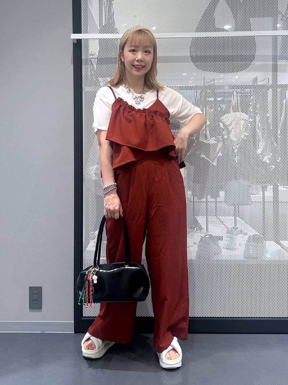 ブラック系のボストンバッグ、ホワイト系のTシャツ/カットソー、レッド系のつなぎ/オールインワンを着用したレディースの夏コーディネートの2枚目の写真