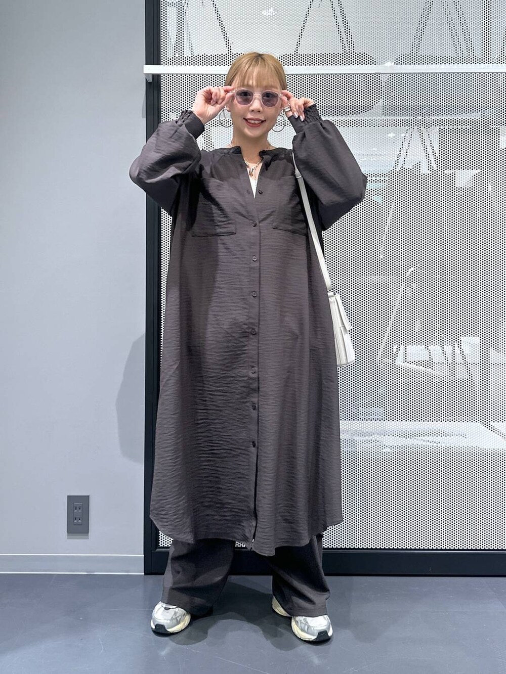 グレー系のその他パンツ、ホワイト系のタンクトップ、ホワイト系のショルダーバッグを着用したレディースの秋コーディネートの6枚目の写真