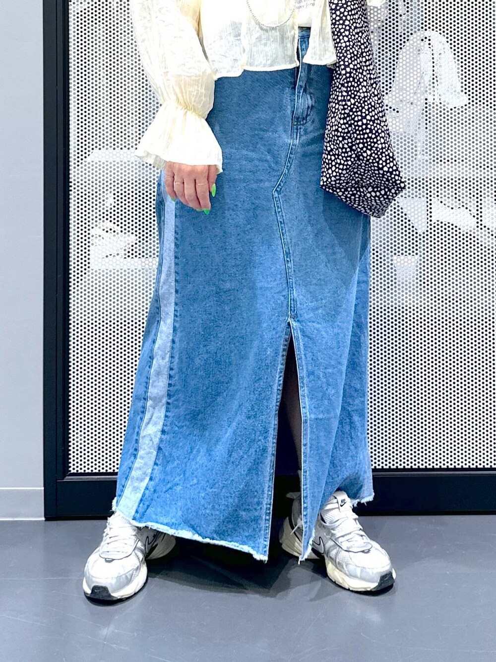 ブルー系のデニムスカート、ベージュ系のシャツ/ブラウス、その他のトートバッグを着用したレディースの春コーディネートの3枚目の写真