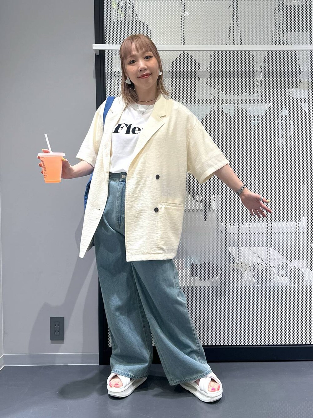 ブルー系のデニムパンツ、ホワイト系のTシャツ/カットソー、ホワイト系のテーラードジャケットを着用したレディースの春コーディネートの2枚目の写真