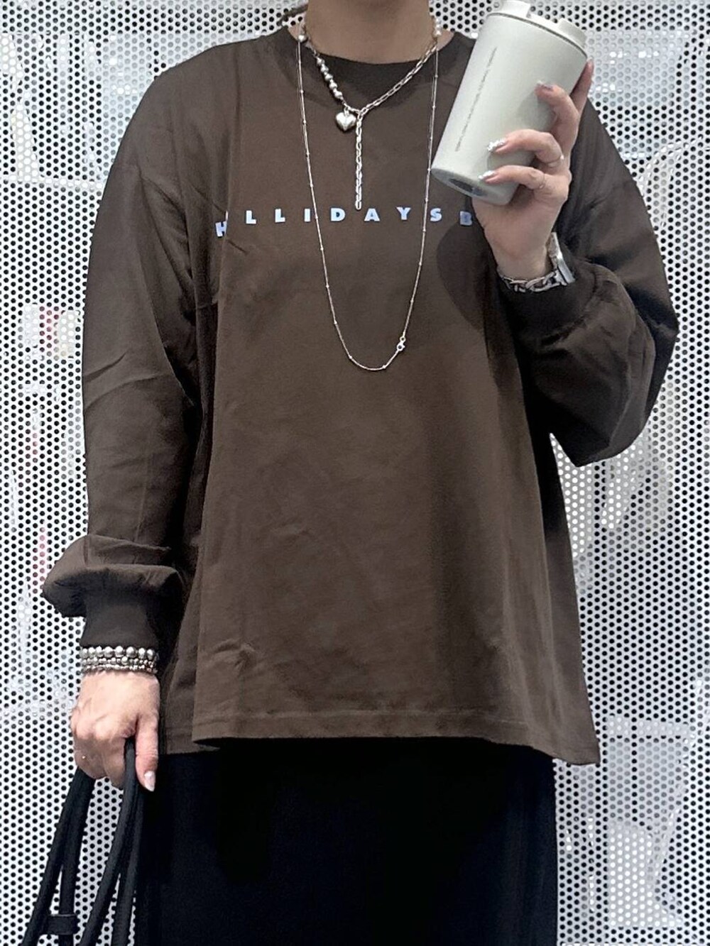 ブラック系のスカート、ブラック系のハンドバッグ、その他のピアス（両耳用）を着用したレディースの秋コーディネートの3枚目の写真