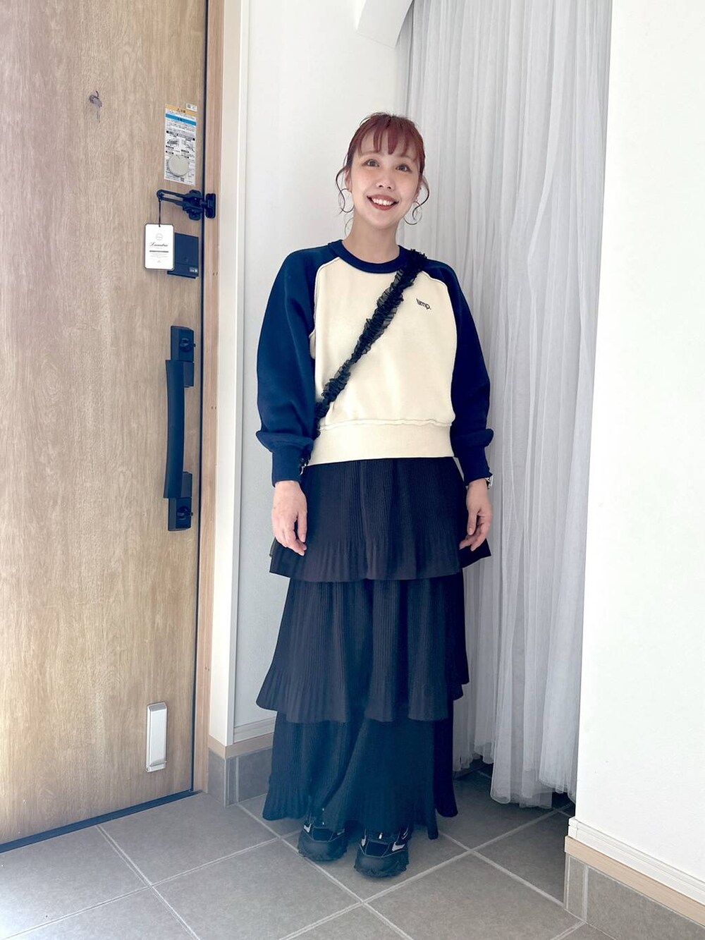 ブラック系のスカート、グレー系のスニーカー、ブルー系のニット/セーターを着用したレディースの秋コーディネートの2枚目の写真