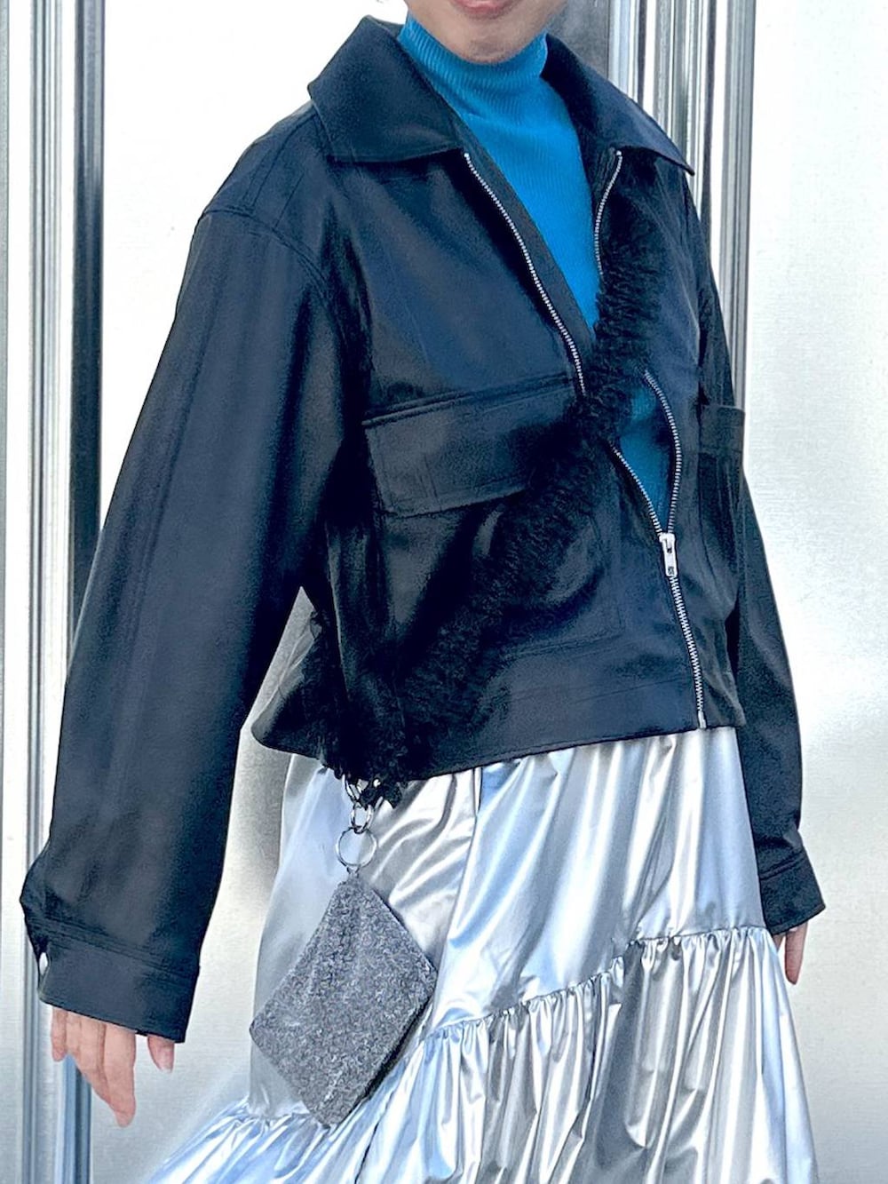 ブラック系のブルゾン、シルバー系のスカート、ブルー系のニット/セーターを着用したレディースの冬コーディネートの4枚目の写真