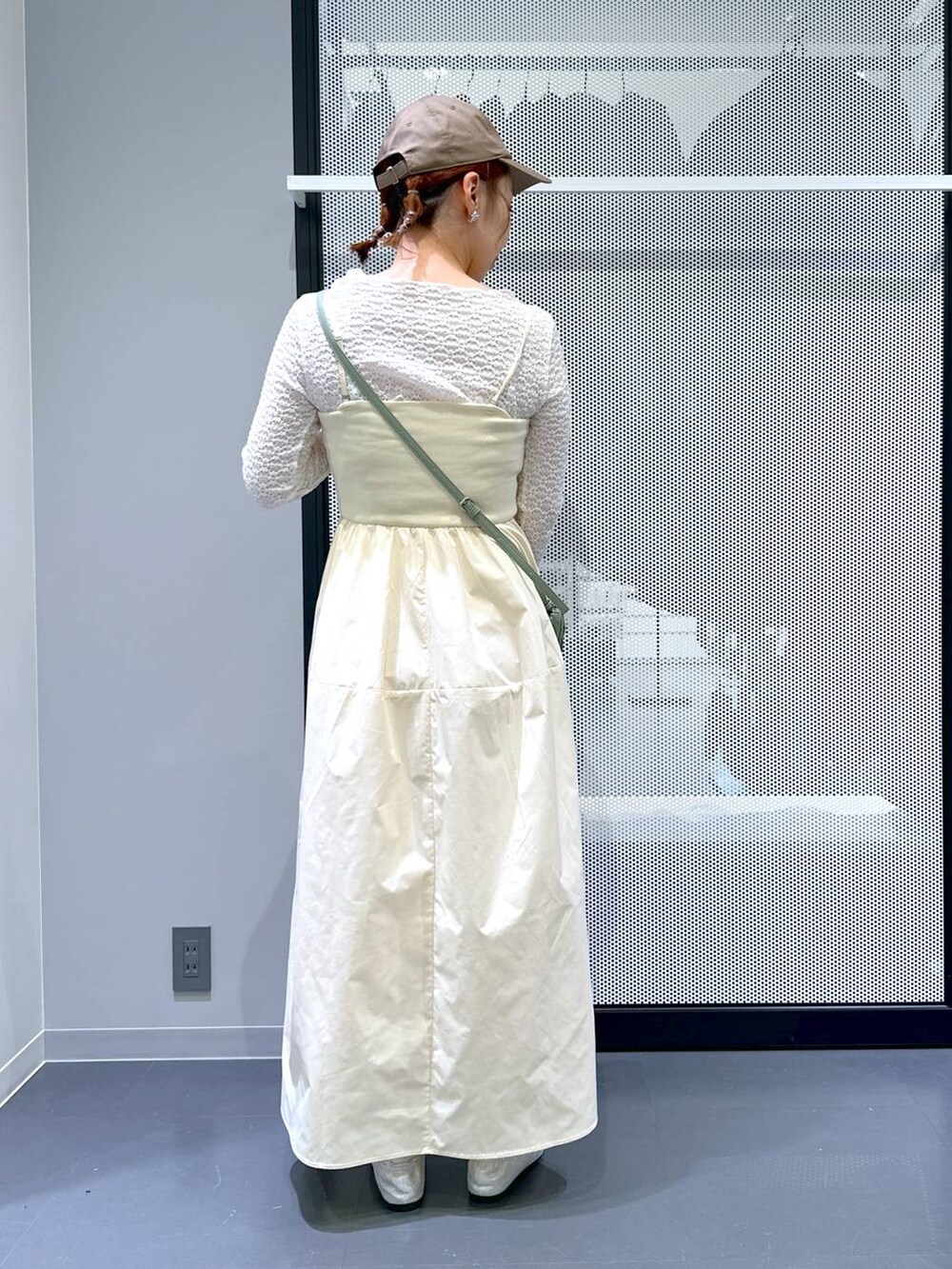 グリーン系のショルダーバッグ、シルバー系のバレエシューズ、ホワイト系のTシャツ/カットソーを着用したレディースの春コーディネートの3枚目の写真