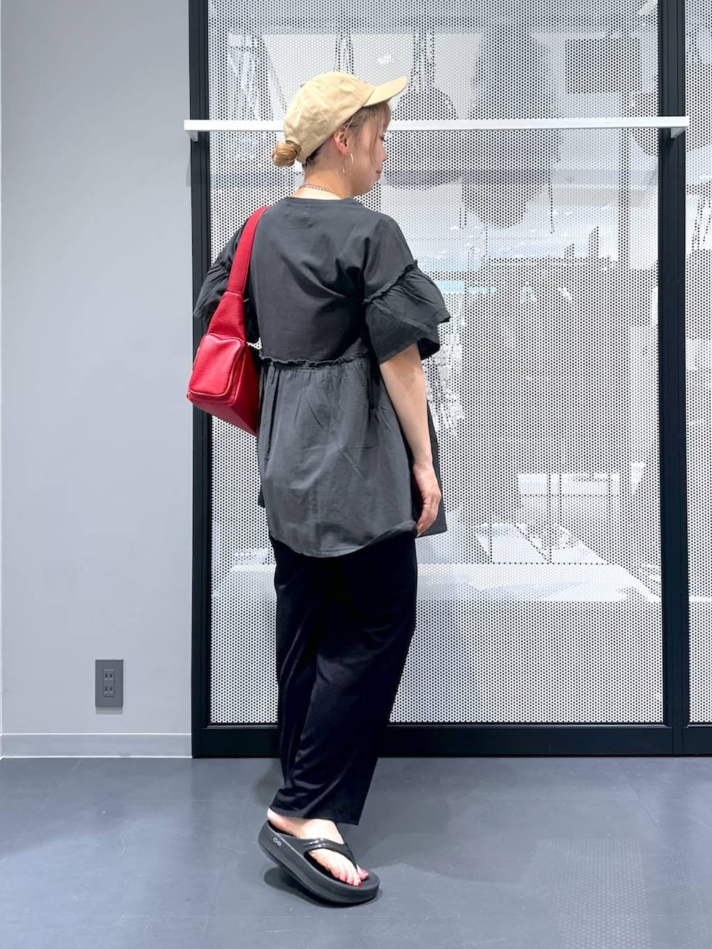 レッド系のショルダーバッグ、ブラック系のサンダル、ブラック系のその他パンツを着用したレディースの夏コーディネートの3枚目の写真