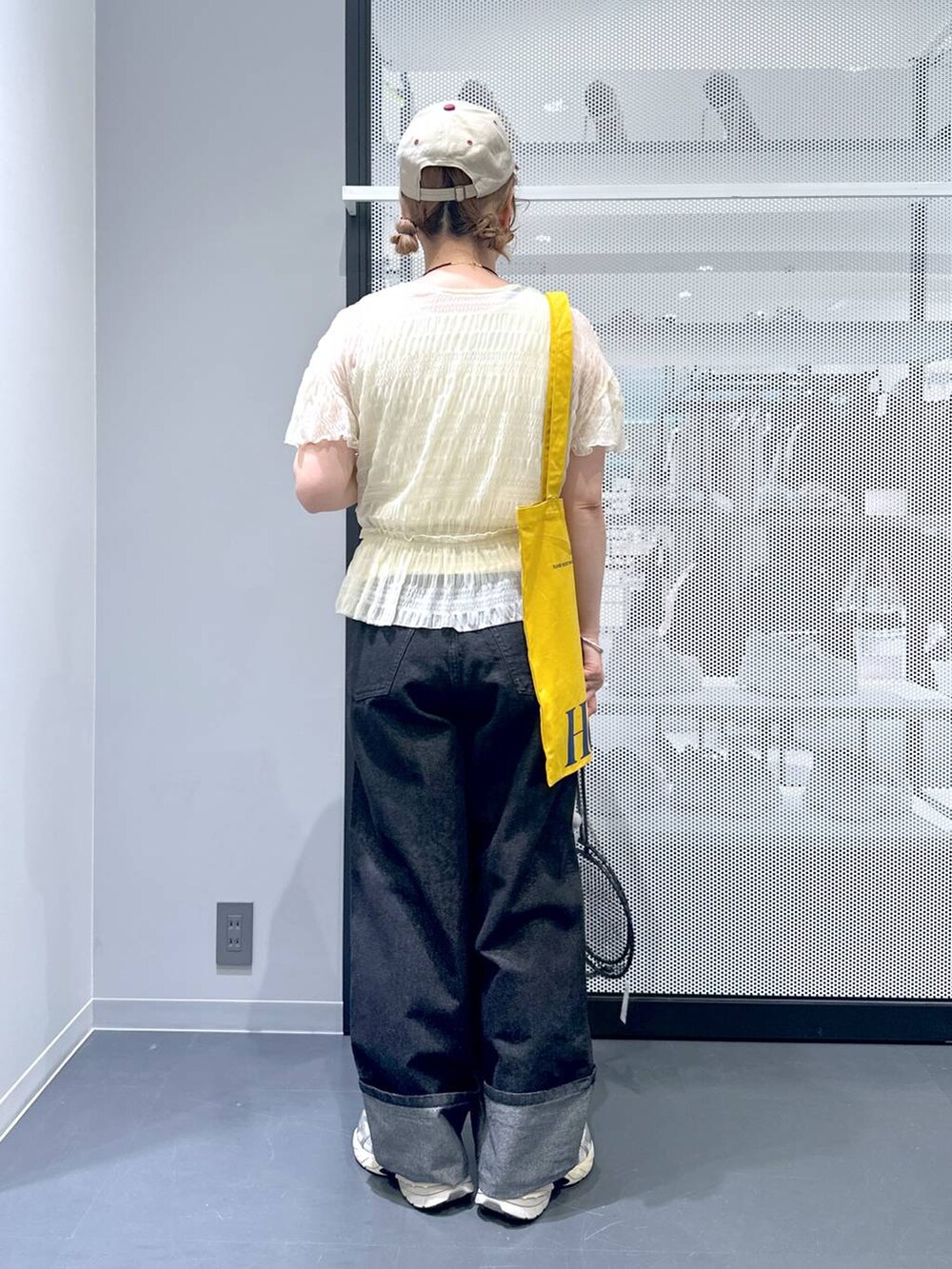 ホワイト系のカーディガン/ボレロ、ブラック系のデニムパンツ、イエロー系のトートバッグを着用したレディースの春コーディネートの4枚目の写真