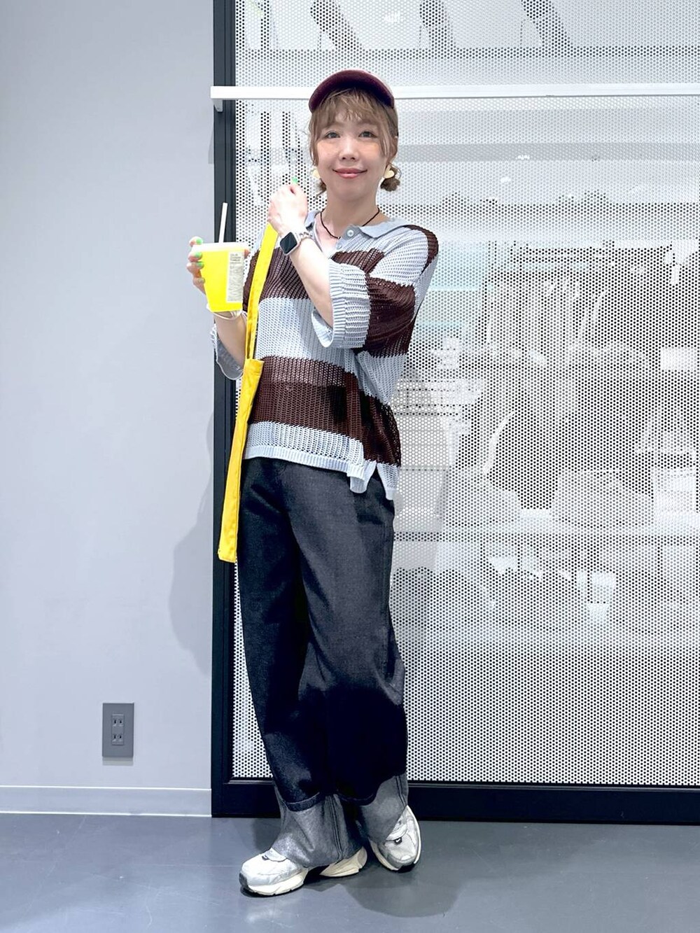 ブラック系のデニムパンツ、イエロー系のトートバッグ、ブルー系のニット/セーターを着用したレディースの春コーディネートの2枚目の写真