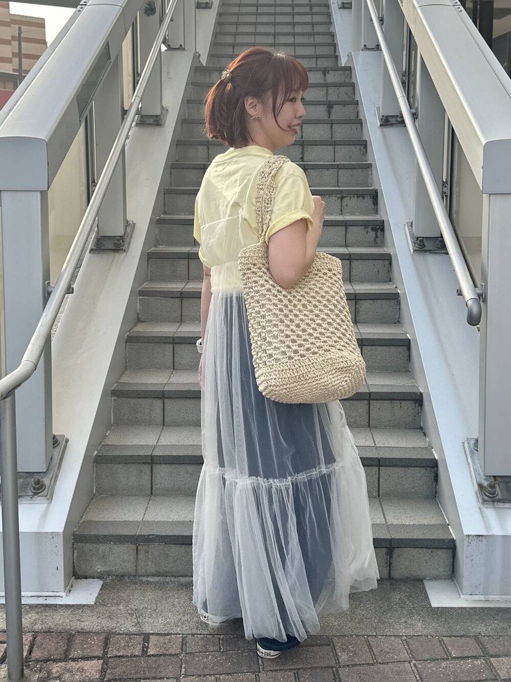 グリーン系のスニーカー、ホワイト系のトートバッグ、ベージュ系のTシャツ/カットソーを着用したレディースの春コーディネートの2枚目の写真